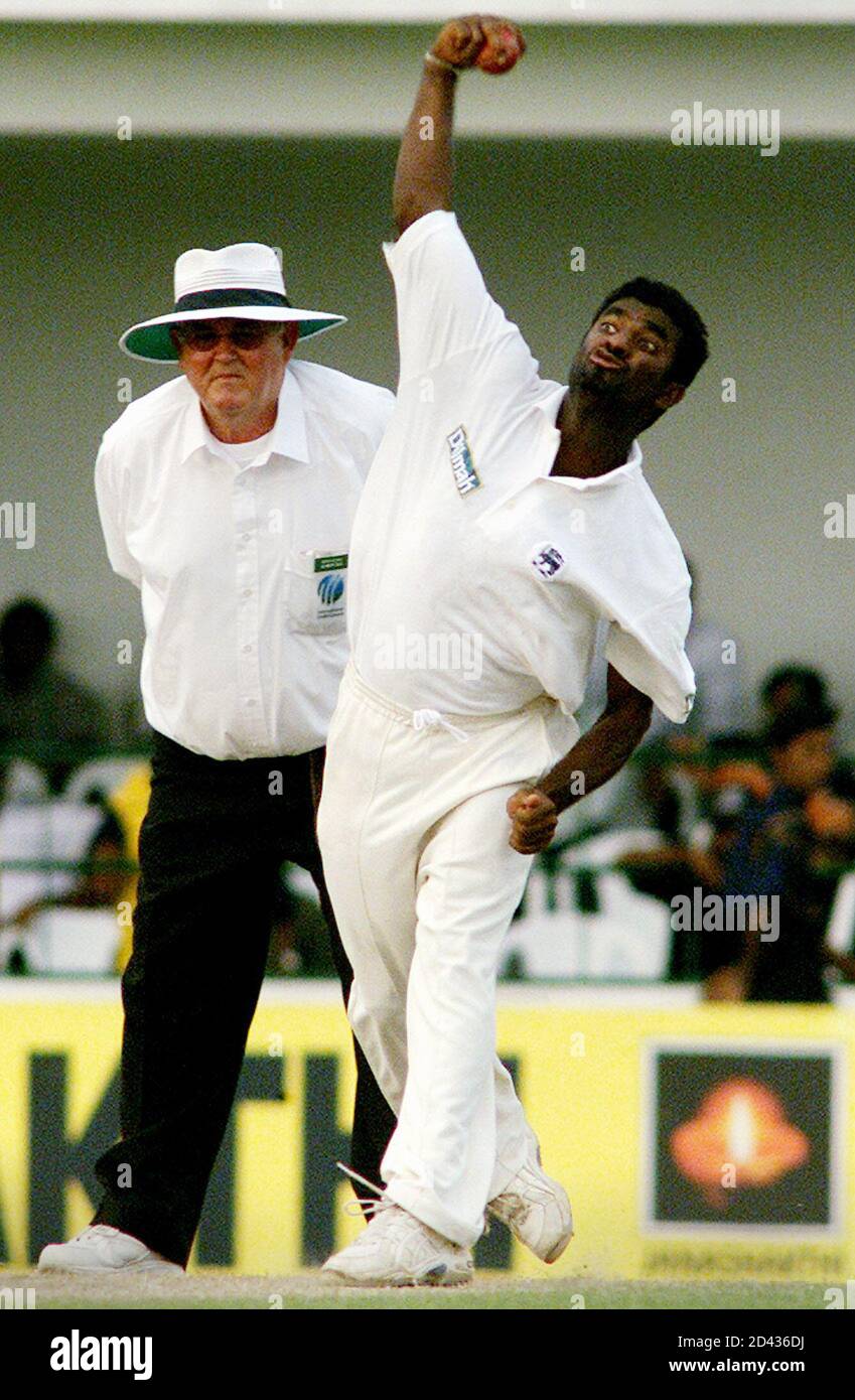 Sri Lankan off spinner Muttiah Muralitharan (R) bowls against Zimbabwe as umpire David Shepherd looks on during the second day of the third cricket test between Sri Lanka and Zimbabwe in Galle, January 13, 2002. Sri Lanka were 418 for all-out their first innings and Zimbabwe are 18 for none at the end of day's play. REUTERS/Anuruddha Lokuhapuarachchi  AL/RCS Stock Photo
