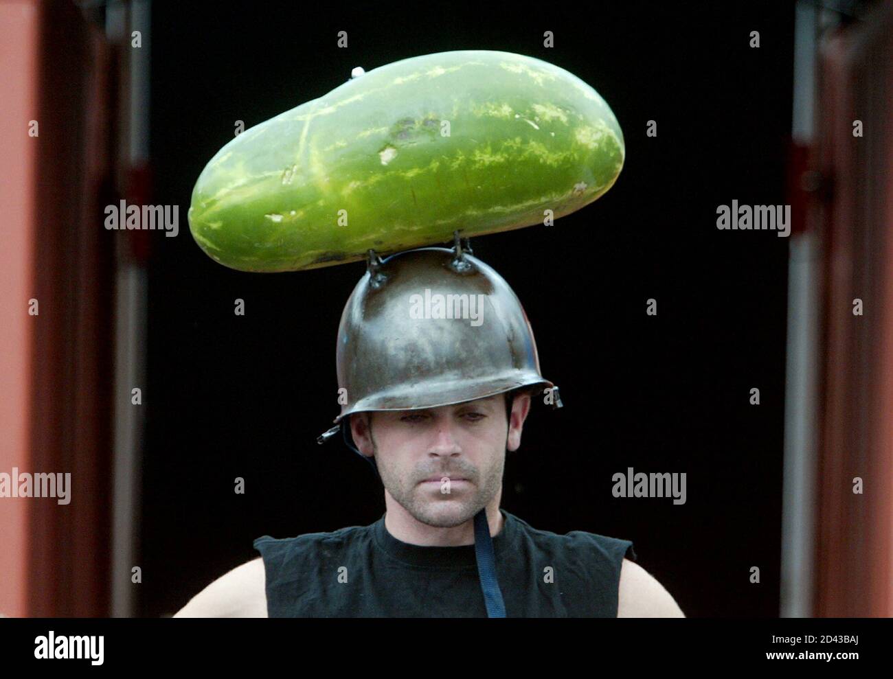 A man from the 'Dare Devil Opera' wears helmet with watermelon on top before it explodes in Sydney March 10, 2004. The exploding watermelon is part of a series of events staged for the amusement of patrons to the Dare Devil Opera, entertainment set to rock music and explosions. REUTERS/Will Burgess HIGH RESOLUTION FILE  WB/SN Stock Photo