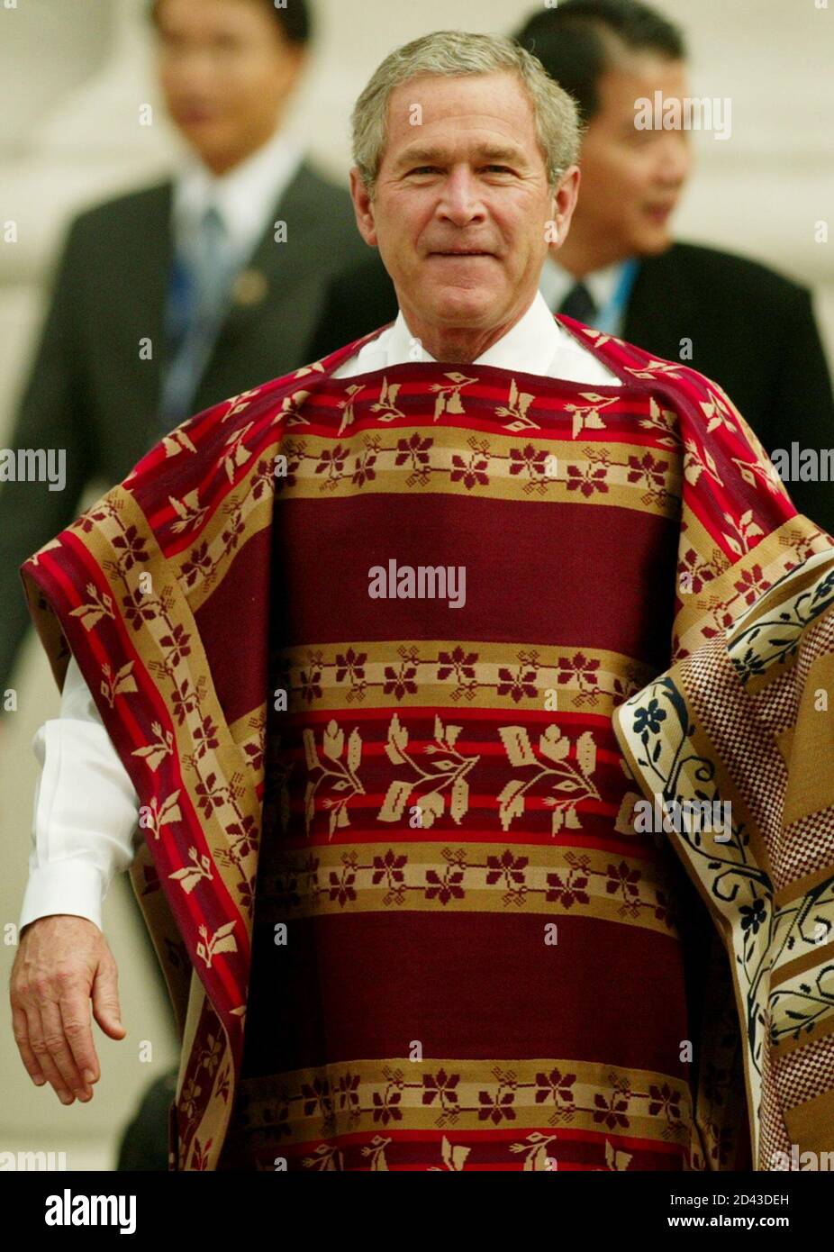 U.S. President George W. Bush wears a traditional Chilean poncho as he  walks to the group photo session of the 21 member countries of the Asia  Pacific Economic Cooperation (APEC), inside La