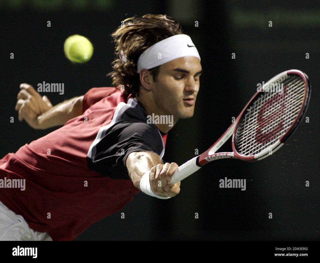 Roger Federer from Switzerland follows through on a backhand shot against  Andre Agassi of the U.S. during their semifinal match at the NASDAQ-100  tennis tournament in Key Biscayne, Florida April 1, 2005.