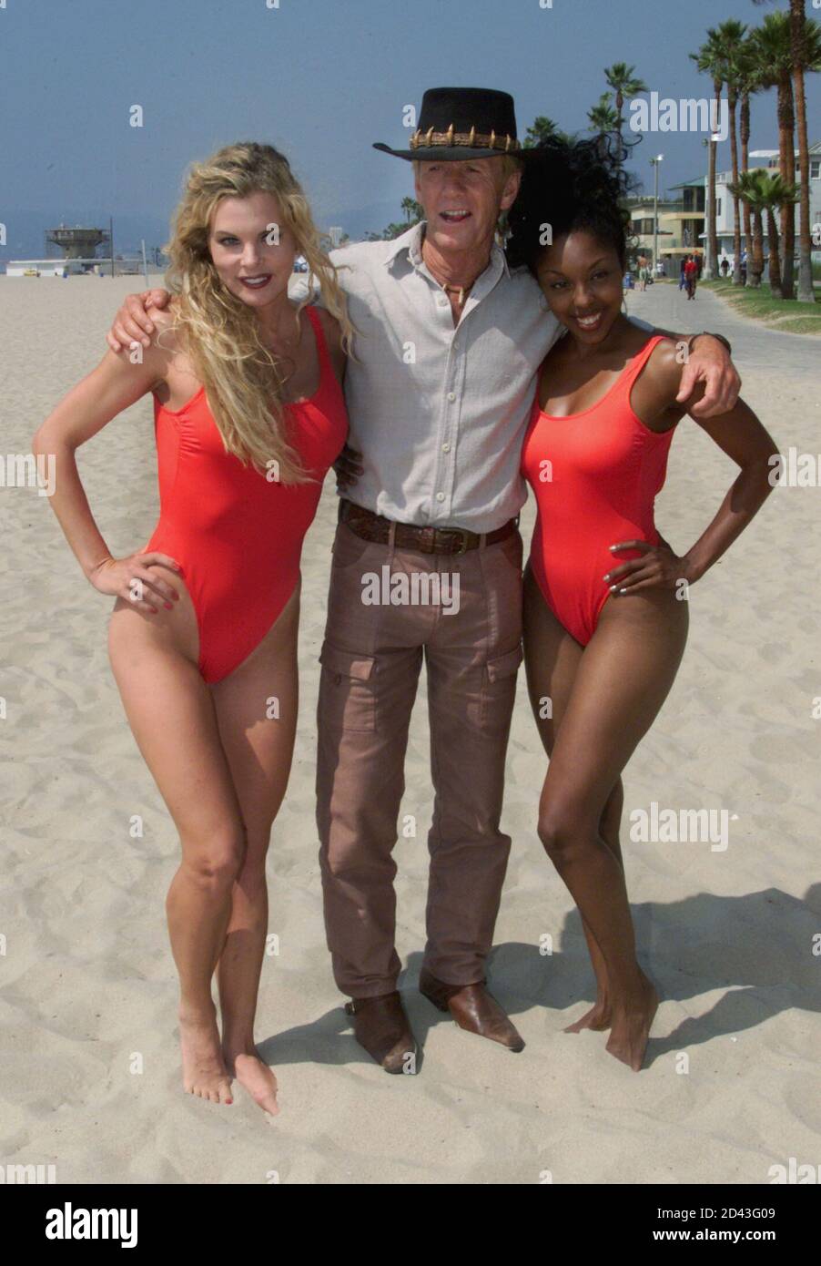 Actor Paul Hogan poses with models during a break in filming on the set of  his latest film " Crocodile Dundee in L.A." September 20, 2000 at Venice  Beach in Los Angeles. [