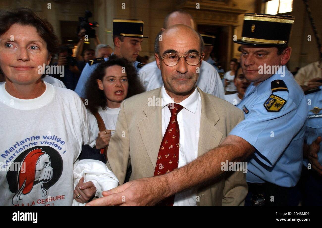 A French gendarme escorts French politician Jean-Yves Le Gallou (C) and a  member of his extreme-right MNR party who wears a tee shirt with the image  of a gagged 'Marianne' (The female