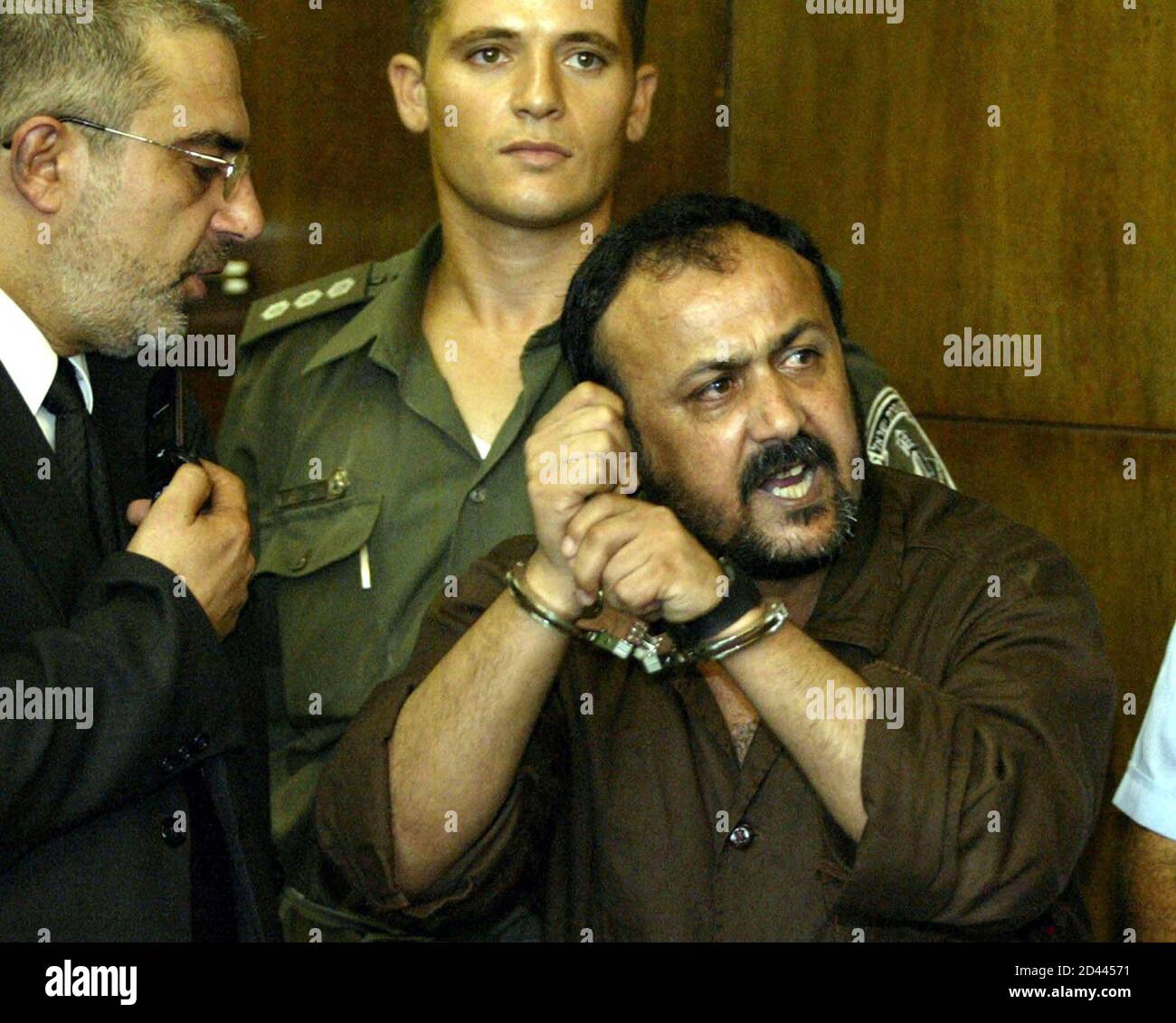 Marwan Barghouti, 43, (R), general secretary of Palestinian [President Yasser Arafat's Fatah ] movement in the West Bank, speaks to the press as his attourney Jamal Bulous (L) tries to stop him at Tel Aviv's city court on August 14, 2002. Shouting in Hebrew, 'the Intifada will win', Marwan Barghouti entered the Israeli court on Wednesday to face murder charges in Israel's first civilian trial of a popular leader of Palestinian uprising. Stock Photo