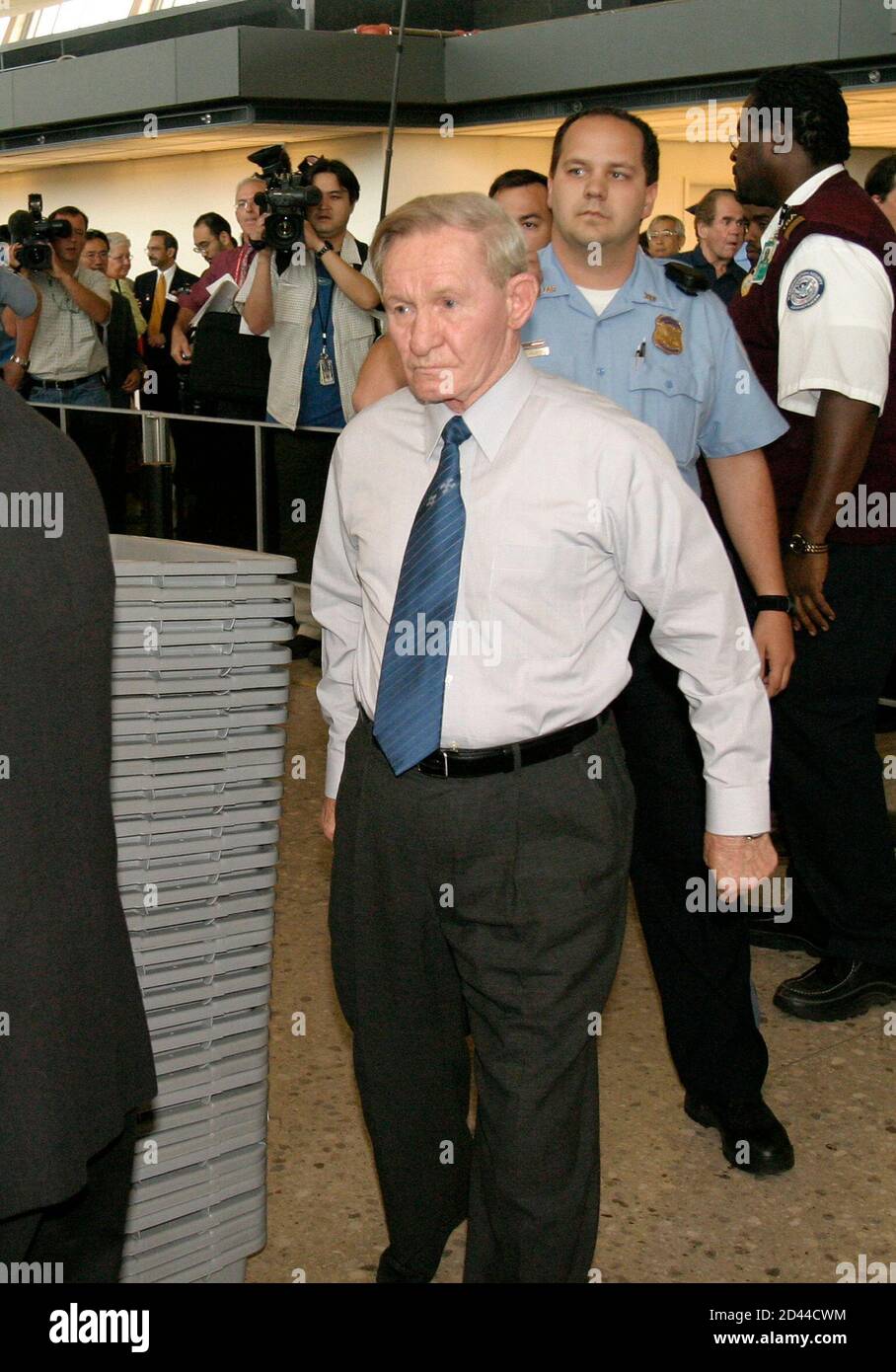 Former U.S. Army deserter Charles Jenkins (C) enters a security line for a connecting flight after arriving at Washington Dulles International Airport in Dulles, Virginia June 14, 2005. Jenkins, 65, deserted to North Korea from South Korea during the Cold War and now lives in Japan with his wife. This is Jenkins' first trip to the U.S. in 40 years which he reportedly intends to spend visiting his elderly mother in North Carolina. REUTERS/Shaun Heasley SH/KI Stock Photo