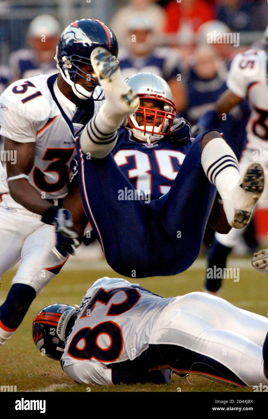 The Denver Broncos Kelly Herndon (31) and Scottie Montgomery (83) upend the New England Patriots Patrick Pass on Pass' kickoff return in first quarter action in Foxboro, Massachusetts October 27, 2002. REUTERS/Brian Snyder  BS Stock Photo