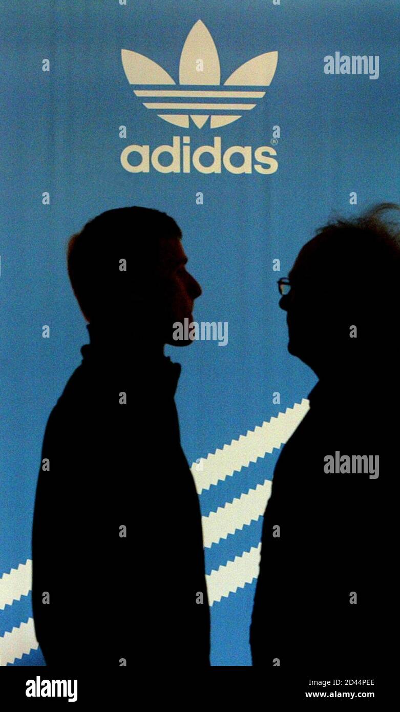 ADIDAS SHAREHOLDERS ARE SILHOUETTED IN FRONT OF THE COMPANY'S LOGO BEFORE  ANNUAL SHAREHOLDER MEETING IN FUERTH. Two unidentified Adidas shareholders  are silhouetted in front of the company's logo before the annual shareholder