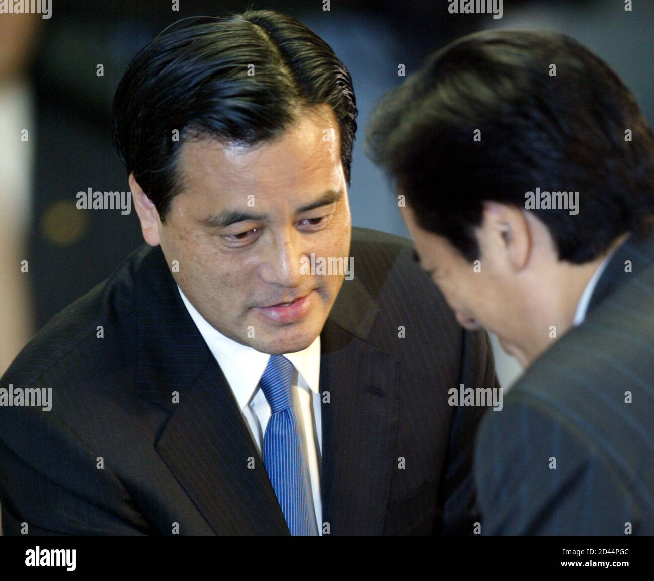 Katsuya Okada, Japan's newly elected opposition Democratic Party leader, greets fomer party leader Naoto Kan at the party's headquarters in Tokyo May 18, 2004. Hit by a furore over missed pension payments that has also ensnared the prime minister, Japan's main opposition party on Tuesday turned to its defacto campaign manager to become leader and rally the ranks ahead of a July election. REUTERS/Issei Kato  IK/SH Stock Photo