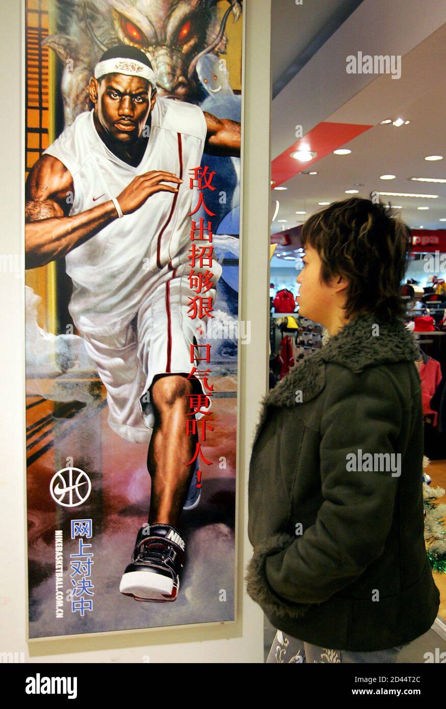 A Chinese shopper walks past NBA star LeBron James' advertisement in  Beijing December 7, 2004. China has kicked up a stink over a Nike footwear  advertisement in which U.S. basketball star LeBron