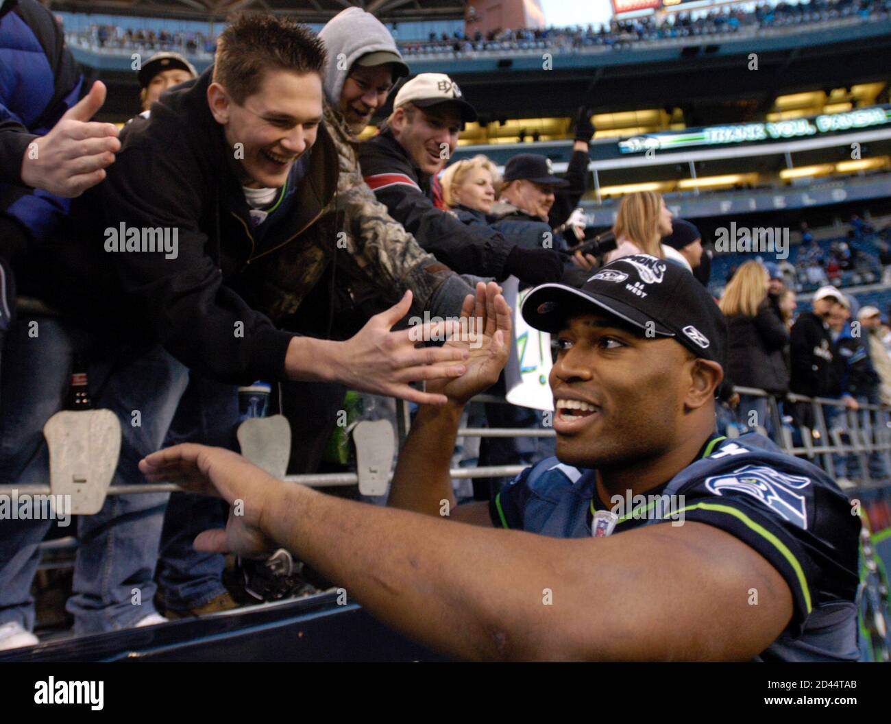 Seattle Seahawks running back Shaun Alexander high-fives fans at Qwest Field in Seattle, January 2, 2005, after the Seahawks beat the Atlanta Falcons, 28-26 to win the NFC West division title. REUTERS/Robert Sorbo  RSS Stock Photo