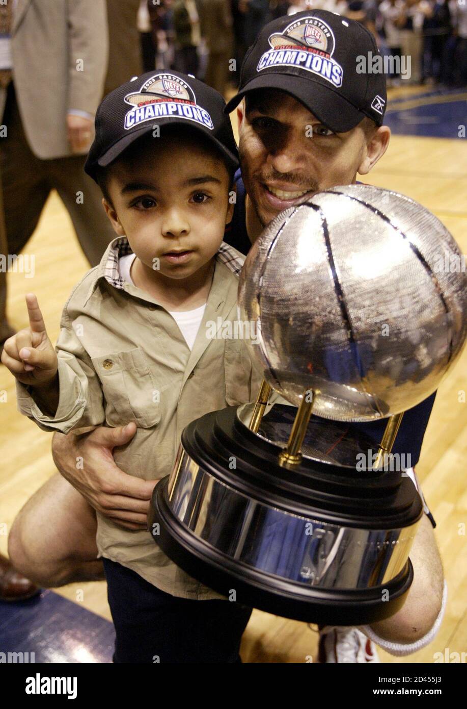 New Jersey Nets guard Jason Kidd holds the NBA Eastern Conference champions  trophy with his son T.J. after the Nets' 102-82 win over the Detroit  Pistons in Game 4 of the NBA
