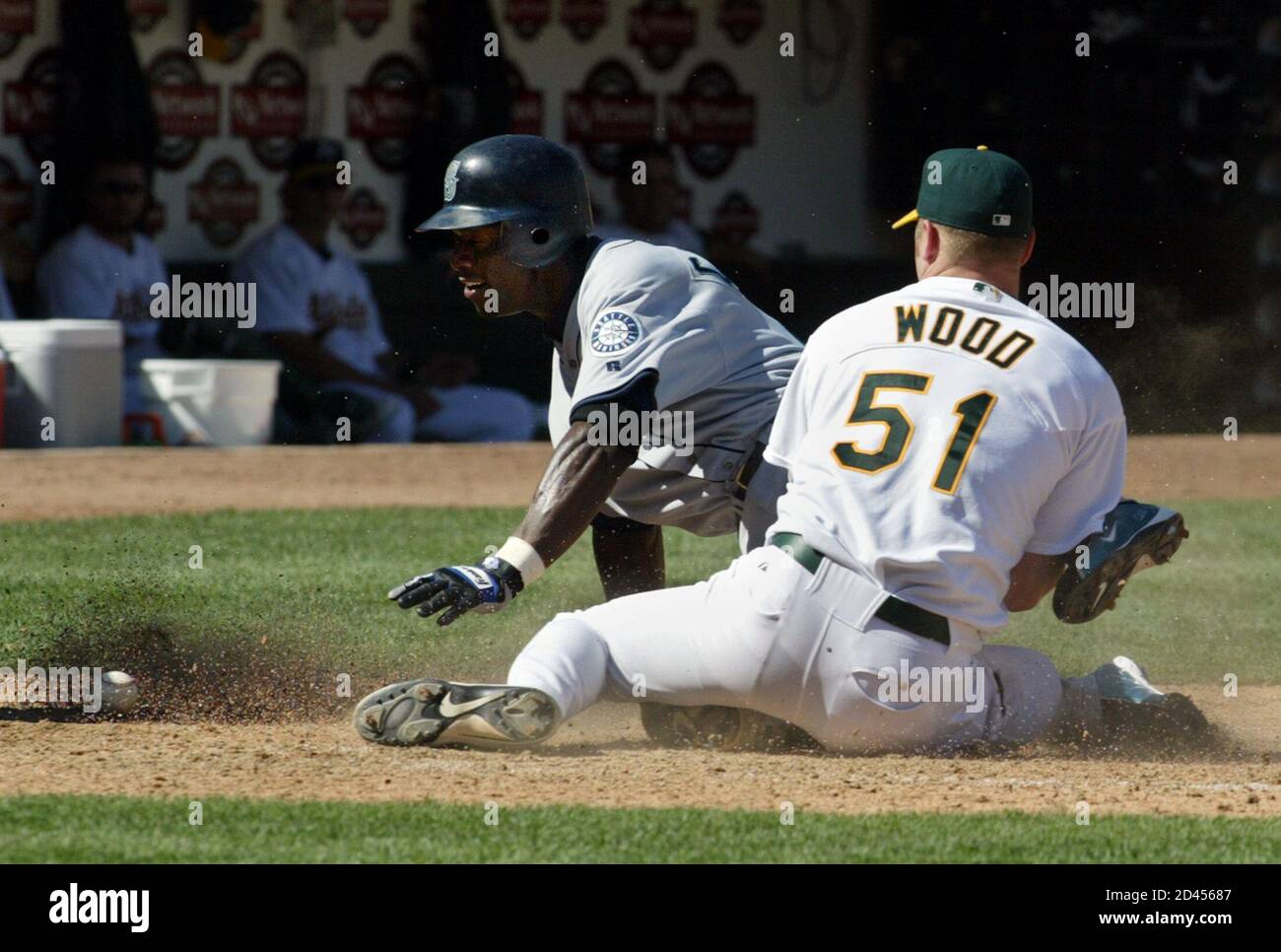 Seattle Mariners' Mike Cameron scores on a wild pitch by Oakland A's  pitcher Mike Wood when Wood could not hold on to a throw back to the plate  from A's catcher Ramon