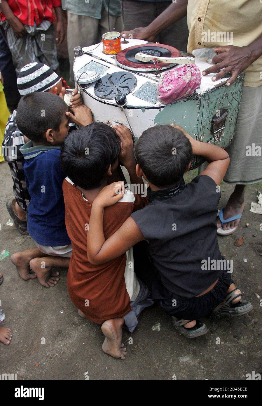 Indian children watch still clips from Bollywood films on a rag-tag  bioscope in the eastern Indian city of Calcutta July 5, 2005. The bioscope  is very popular in Indian villages where children