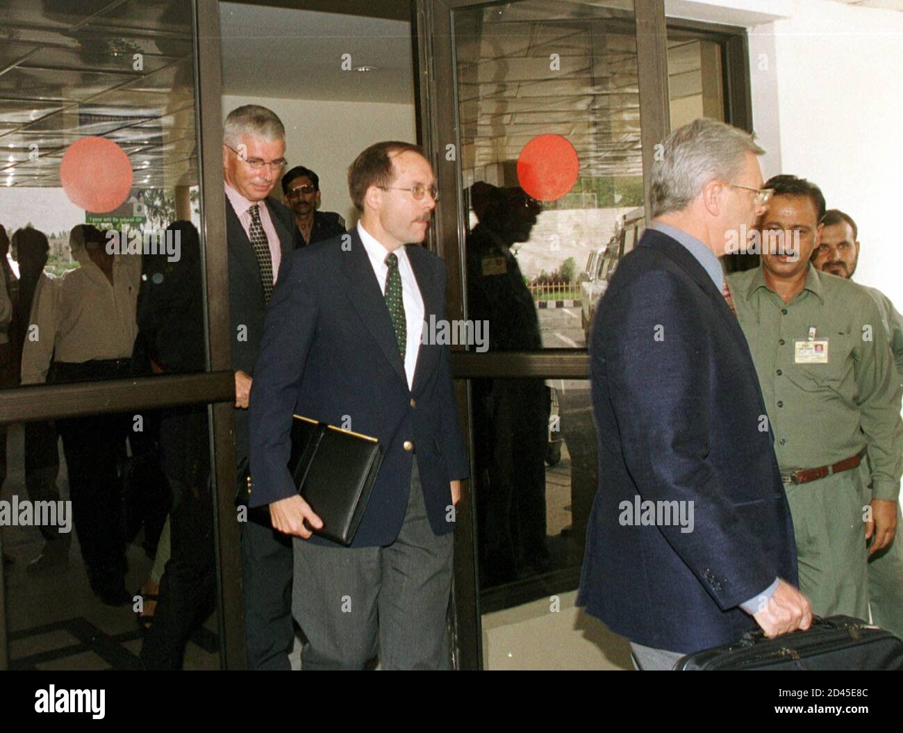 Australian consul Alistair Adams (R), U.S. Consul General David Donahue (C) and German diplomat Helmut Landes (extreme left) leave the VIP lounge at Islamabad airport after arriving from Kabul, August 21, 2001. The diplomats returned from Afghanistan following a futile week-long effort to visit their eight citizens detained on charges of promoting Christianity.  AH/RCS Stock Photo