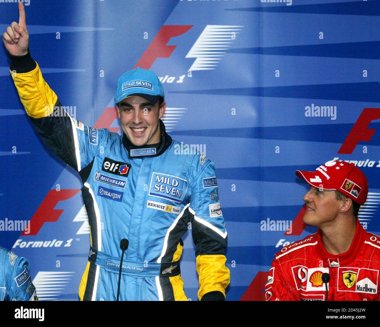 Renault Formula One driver Fernando Alonso of Spain (L) gestures during a  news conference after he took his first pole position of his Formula One  career at Sepang International Circuit, Malaysia March
