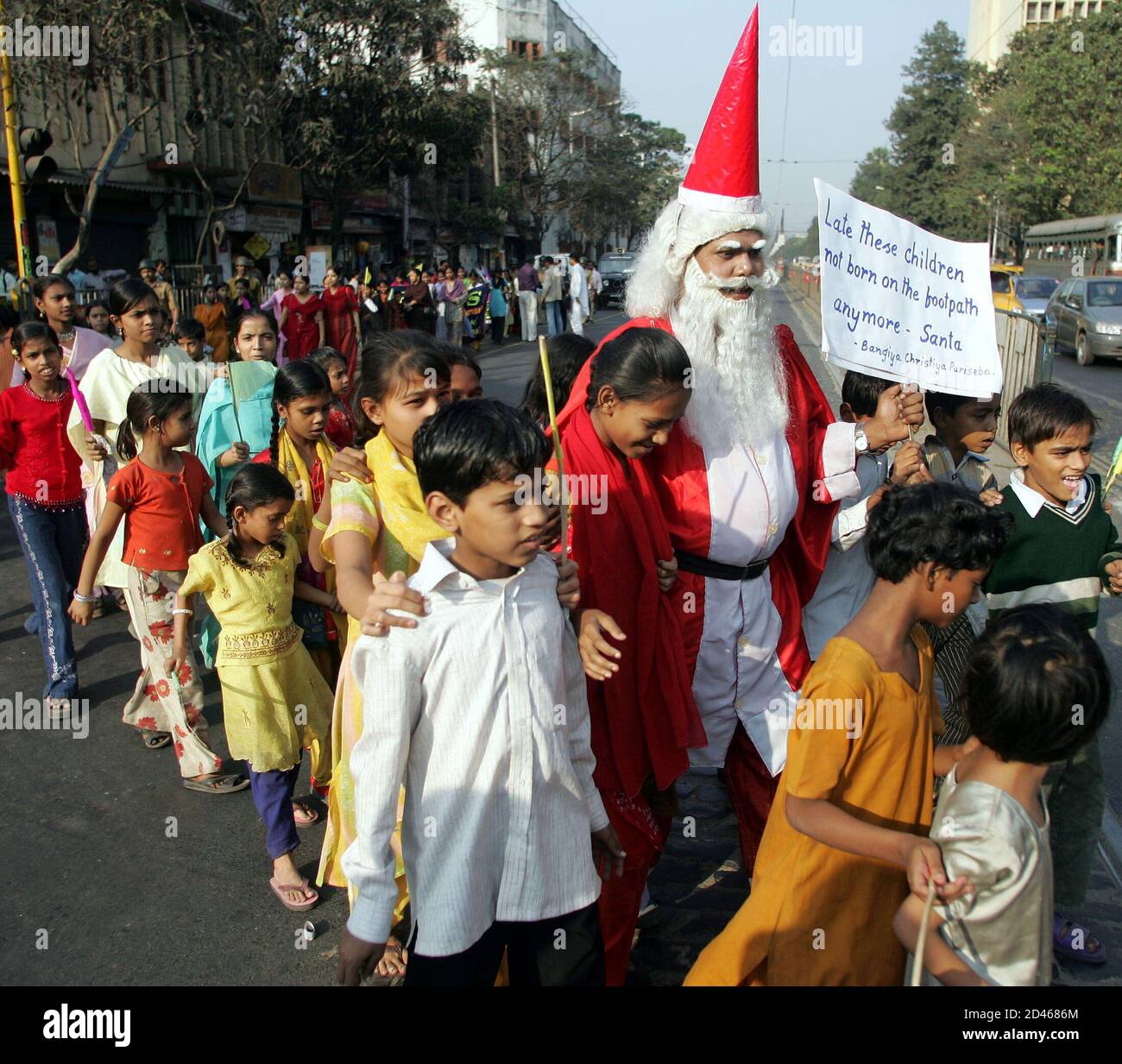 An Indian man dressed as Santa Claus leads a march of street children in Calcutta December 21, 2004. About 200 street children participated in the rally, which was organised by a Christian group pressing for better living conditions for these disadvantaged youngsters. REUTERS/Jayanta Shaw  JS/LA Stock Photo