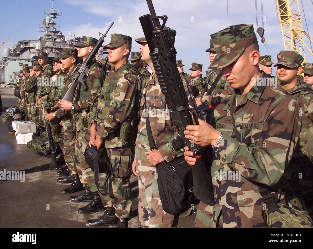 U.S. Marine Cpl. Esteban Medina inspects his M-203 rifle while waiting with the rest of Battalion Landing Team 14 to board the USS Bonhomme Richard at Naval Station San Diego enroute to the Arabian Sea on November 30, 2001. U.S. Defense Secretary Donald Rumsfeld on Friday rejected any negotiated surrender of the besieged Afghan Taliban stronghold of Kandahar in exchange for amnesty for Taliban supreme leader Mullah Mohammad Omar. REUTERS/Fred Greaves  FG/ME Stock Photo