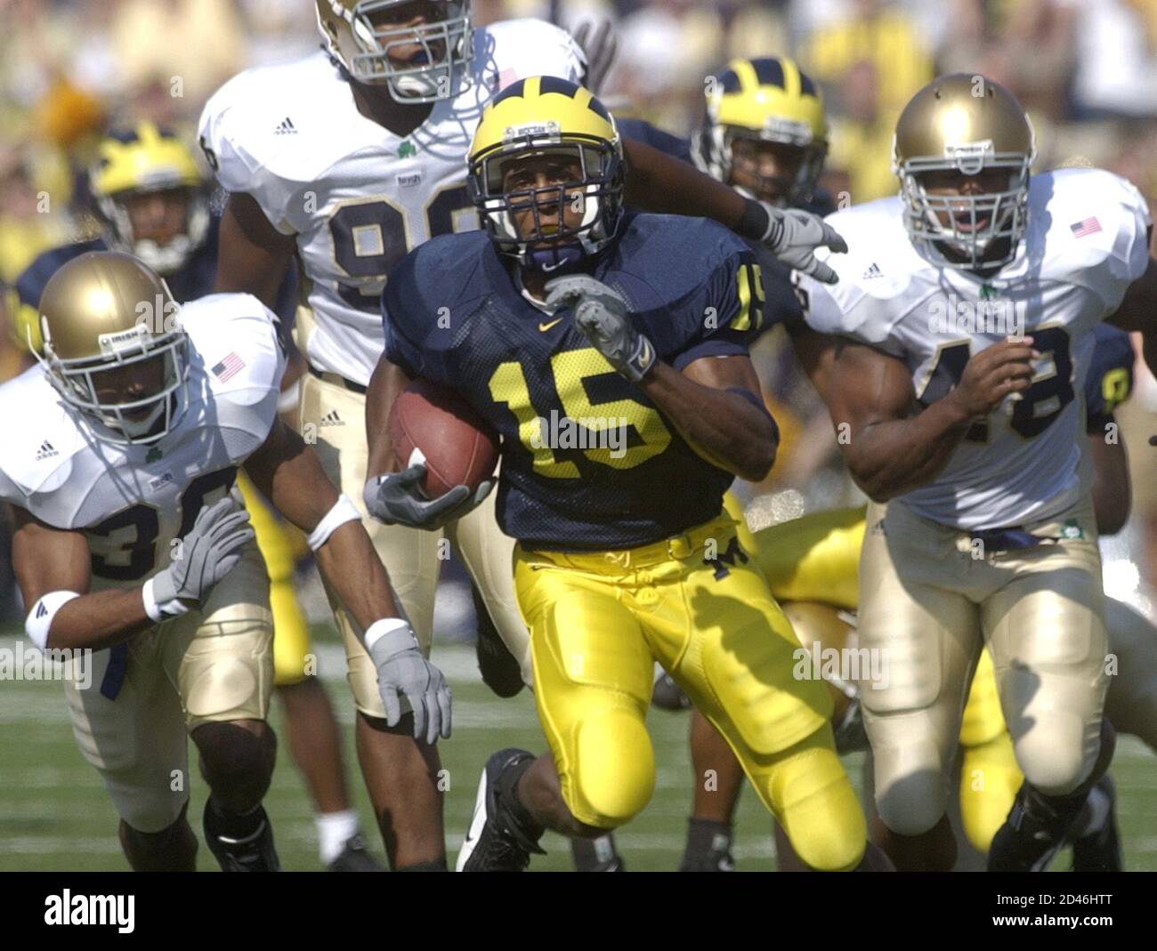 University of Michigan's wide receiver Steve Breaston (15) rushes in front  of Notre Dame defensive end Jason Sapp (99) and defensive end Jerome  Collins (48) for 55 yards on a punt return,