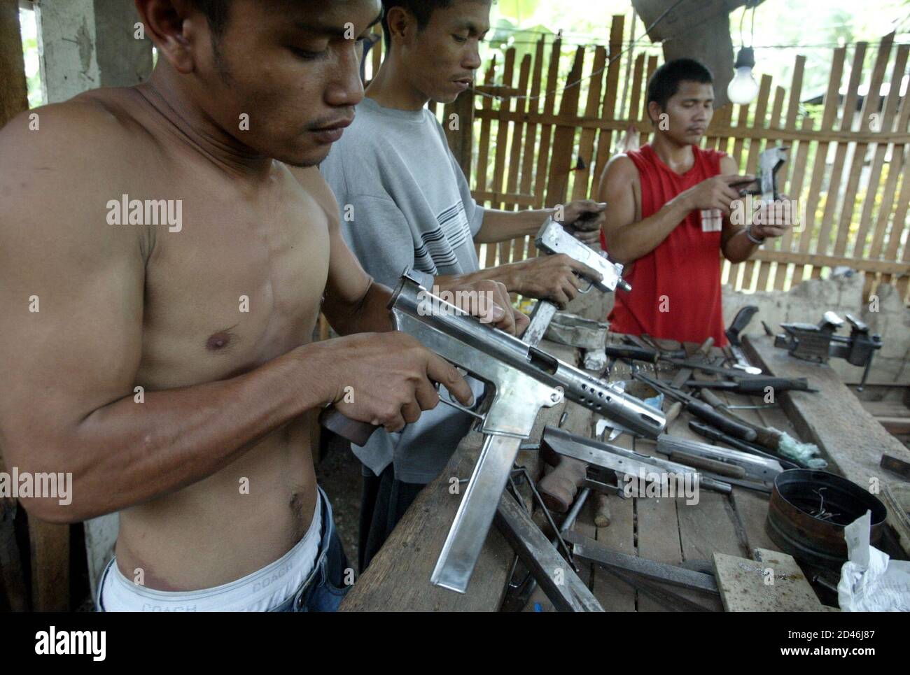 photo-taken-27nov03-filipino-gunsmiths-fine-tune-their-machine-pistols-in-a-clandestine-factory-in-danao-town-in-central-philippines-november-27-2003-illegal-gunmakers-in-the-philippine-island-of-cebu-are-expecting-a-brisk-sales-ahead-of-next-mays-presidential-elections-which-is-shaping-up-to-be-one-of-the-most-bitterlty-fought-polls-on-record-2D46J87.jpg