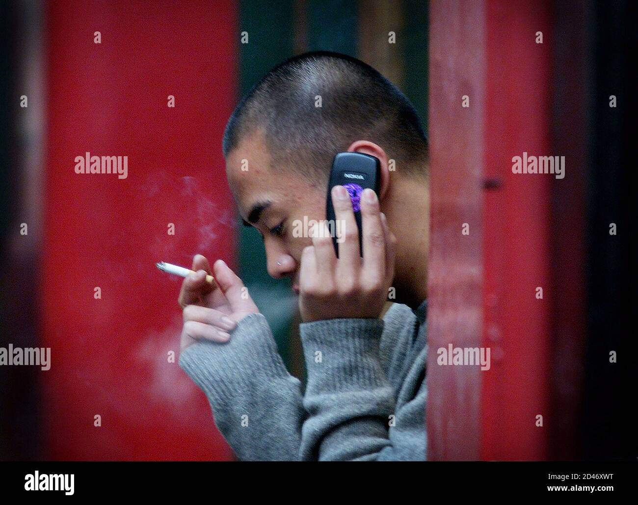 A young man talks on his mobile phone outside a shop in central London, January 25, 2002. Britain launched a 7.4 million pound ($10.5 million) research programme on Friday to investigate whether mobile phones pose a health risk. REUTERS/Ferran Paredes  FP/ASA Stock Photo