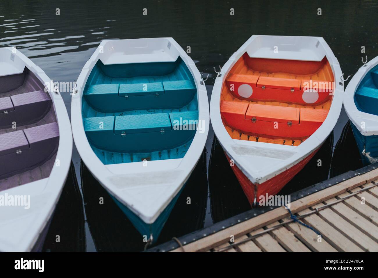 Boats tied to the wooden dock by the lake Stock Photo - Alamy