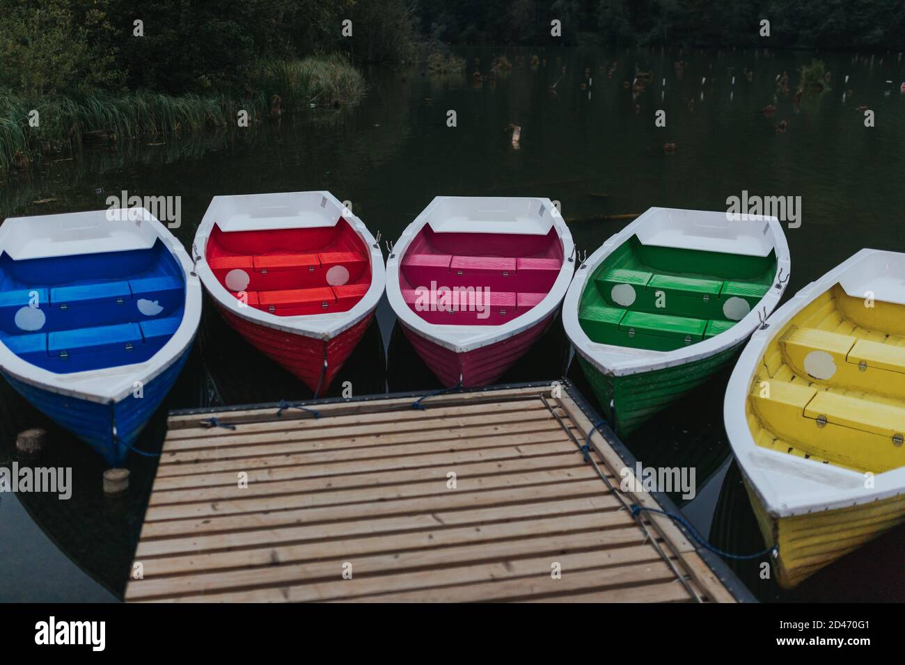 Boats tied to the wooden dock by the lake Stock Photo - Alamy