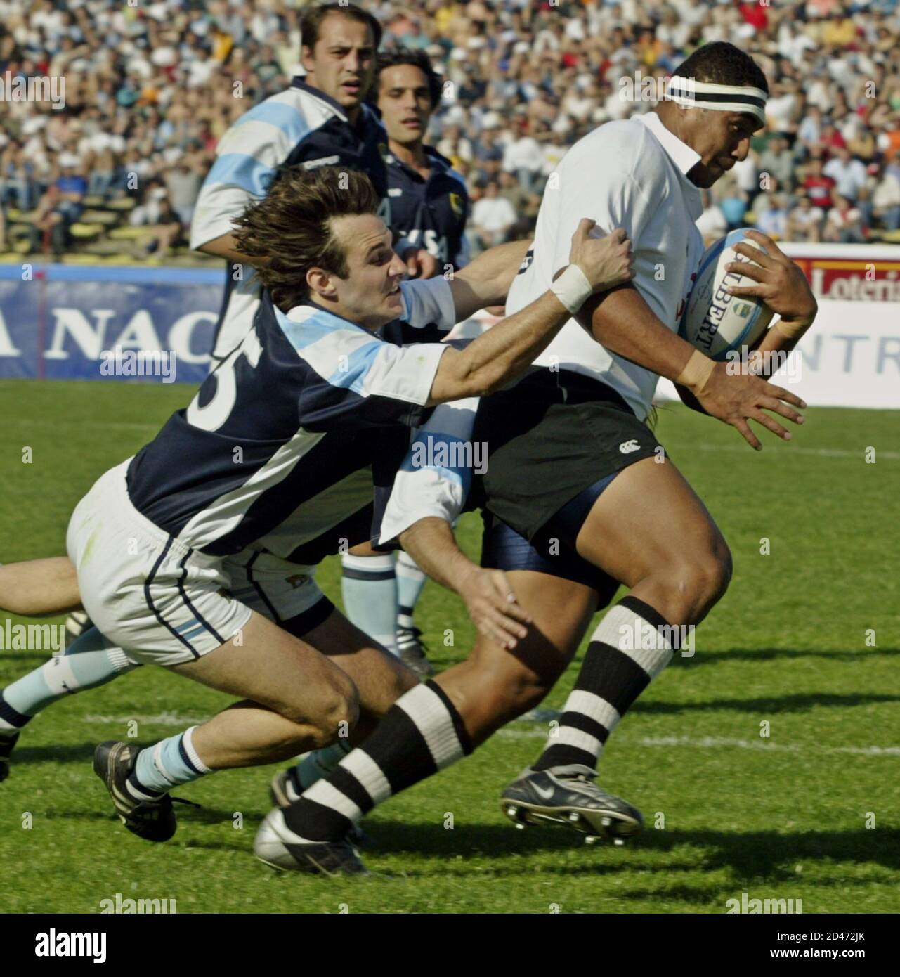 Fijis' Sisa Koyamaibole (R) runs away from Argentine Los Pumas' Bernardo  Stortoni at their rugby test match played in the Argentine northern  province of Cordoba, August 18, 2003. Los Pumas defeated Fiji