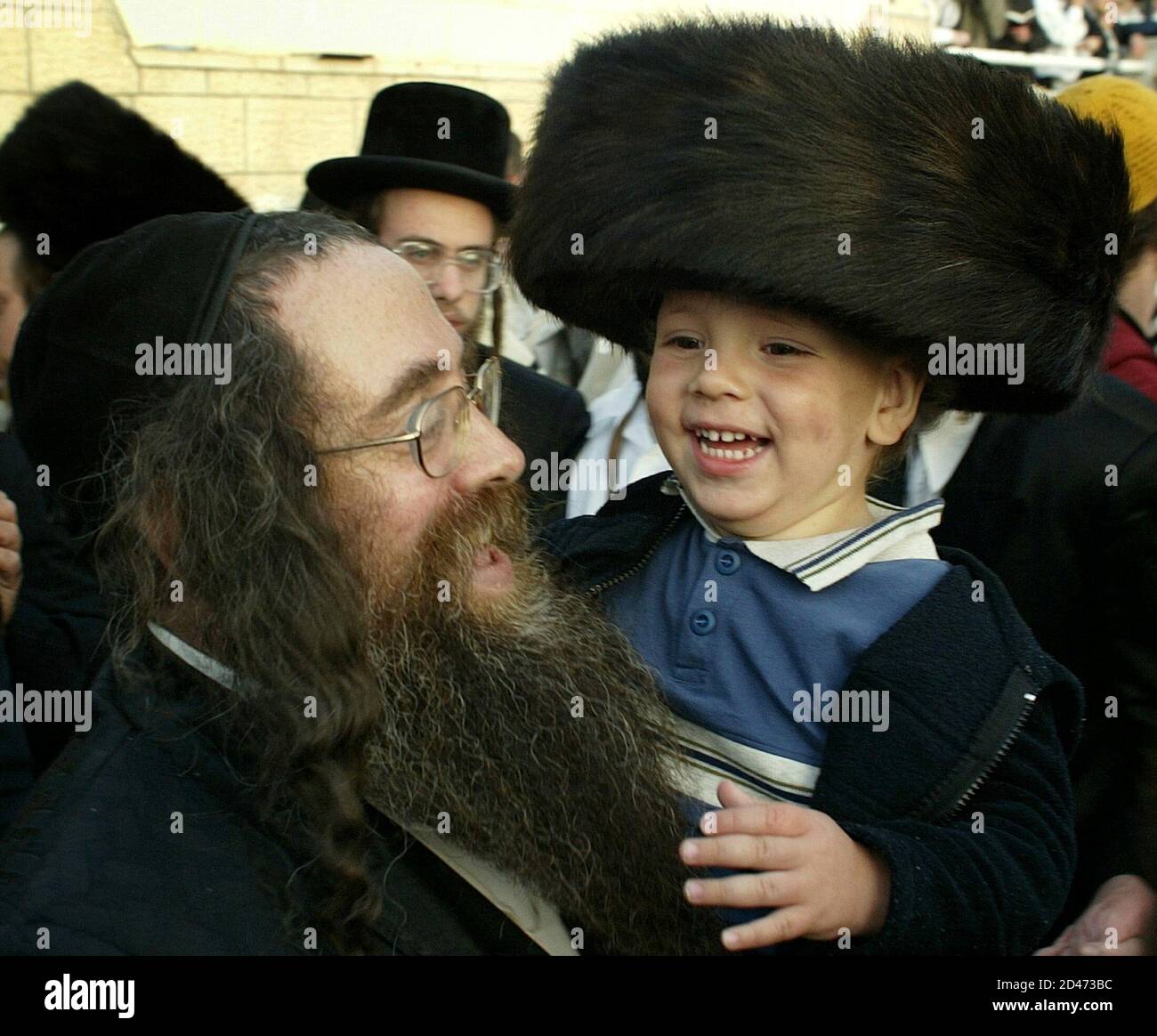 An ultra Orthodox Jew holds a 3-year-old boy after having his hair cut for the first time during Lag Ba-Omer festivities on Meron montain at the grave of a second-century mystic in An ultra Orthodox Jew holds a 3-year-old boy after having his hair cut for the first time during Lag Ba-Omer festivities on Meron montain at the grave of a second-century mystic in