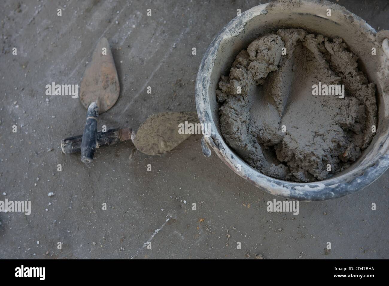 Plastering trowel mixed cement in a bucket on the floor in construction site Stock Photo