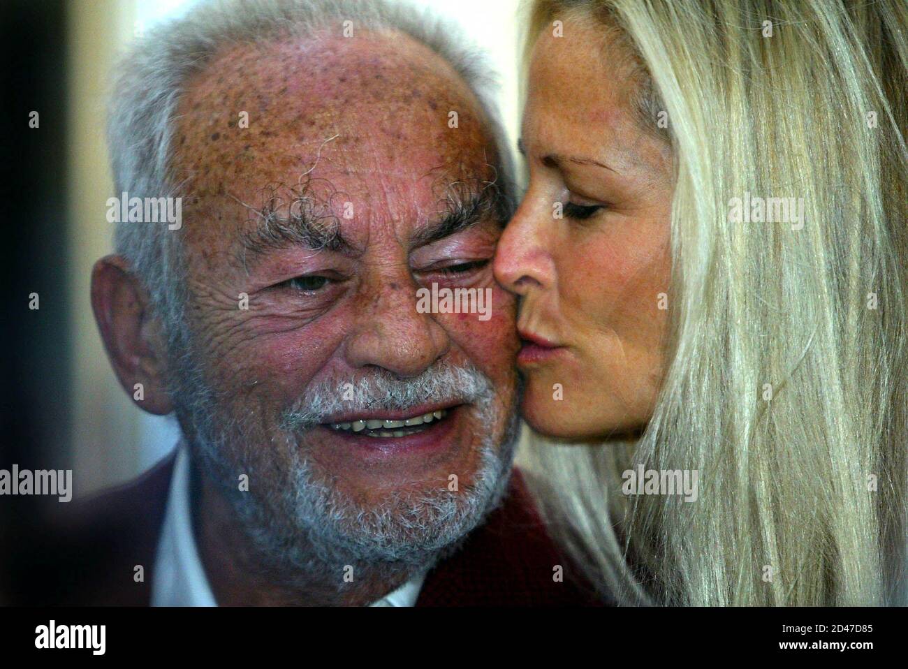 Legendary Italian film producer Dino di Laurentis smiles as he receives a  kiss from his wife Rita prior to a press conference at a hotel in central  Rome October 15, 2002. [Laurentis