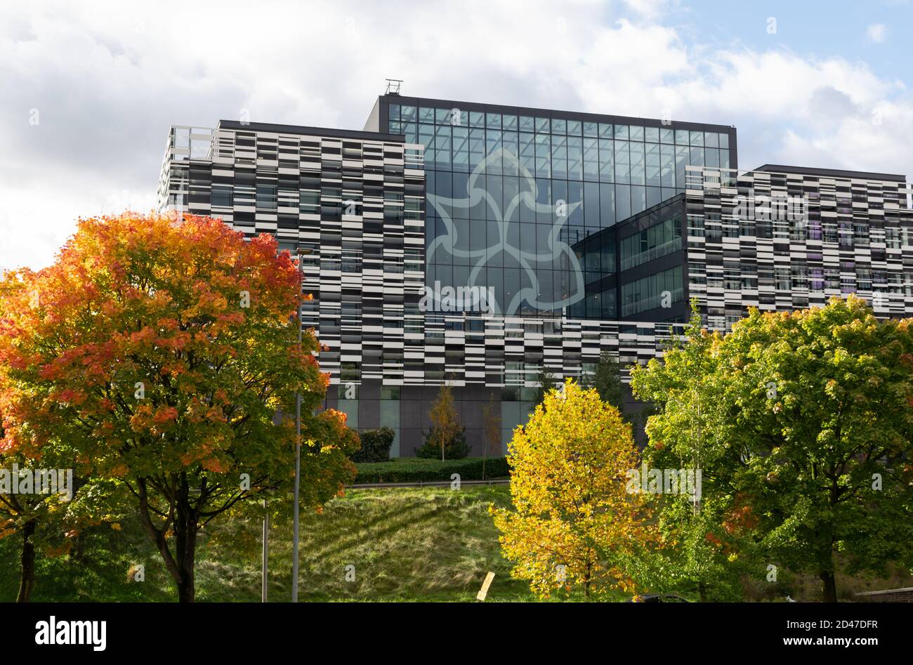 Brooks Building on the Birley Fields campus. Manchester Metropolitan University, UK  logo of six spade irons. Trees with autumn, fall colours. Stock Photo