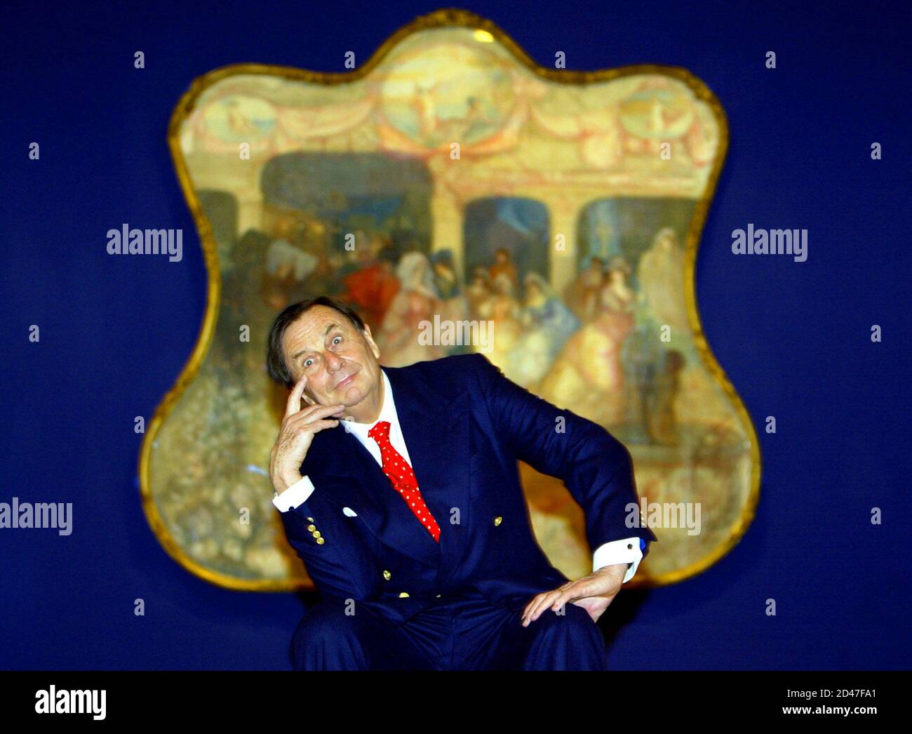 Australian comedian Barry Humphries poses in front of one of Australian artist Charles Condor's paintings at the launch of his retrospective at the New South Wales Art Gallery in Sydney June 12, 2003. Humphries, who owns alot of the works in the show, officially opened the exhibition which inlcudes 112 paintings of the world-renowned artist's watercolours, drawings and prints. Stock Photo