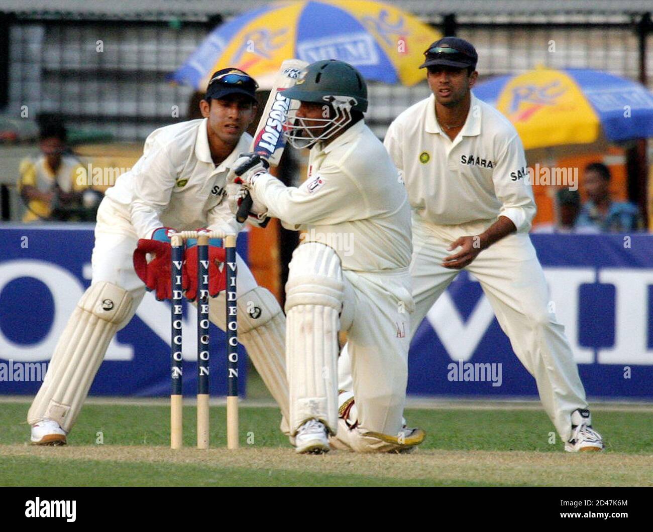 Bangladesh batsman Mohammad Rafiq plays a ball as wicket keeper Dineh Mongia (L) and Rahul Dravid (R) watch during the first day of the first test against India in Dhaka.  Bangladesh batsman Mohammad Rafiq plays a ball as wicket keeper Dineh Mongia (L) and Rahul Dravid (R) watch during the first day of the first test against India in Dhaka stadium on December 10,2004. Bangladesh were all out for 184 runs. REUTERS/Rafiqur Rahman Stock Photo