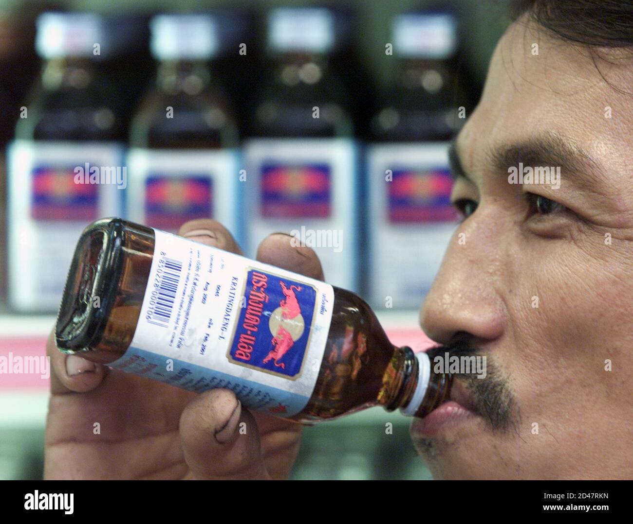 A Thai Man Drinks A Bottle Of Krating Daeng An Original Thai Version Of Popular Drink Red Bull In A Store In Bangkok On July 24 01 The Caffeinated Refreshment Marketed As