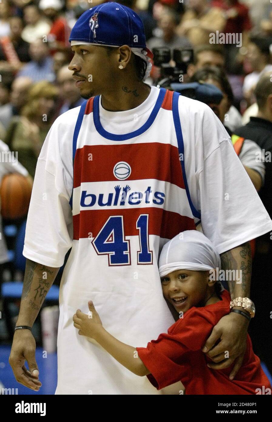 USA guard Allen Iverson and his son Allen Iveson Jr. stand on the court  after the USA defeated Puerto Rico 87-71 during the semifinal round of the  2003 FIBA Americas Men's Olympic