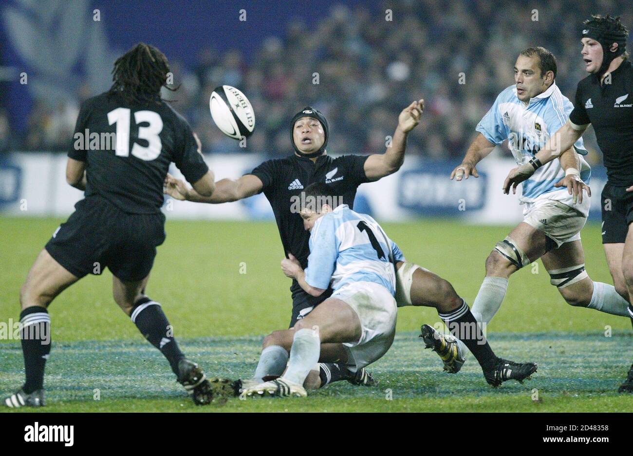 All Black Mose Tuiali'i offloads to Tana Umaga (L) as he is tackled by  Argentina's Pablo Gomez Cora and watched by Rodrigo Roncero and Richard  McCaw (R) during the rugby union international