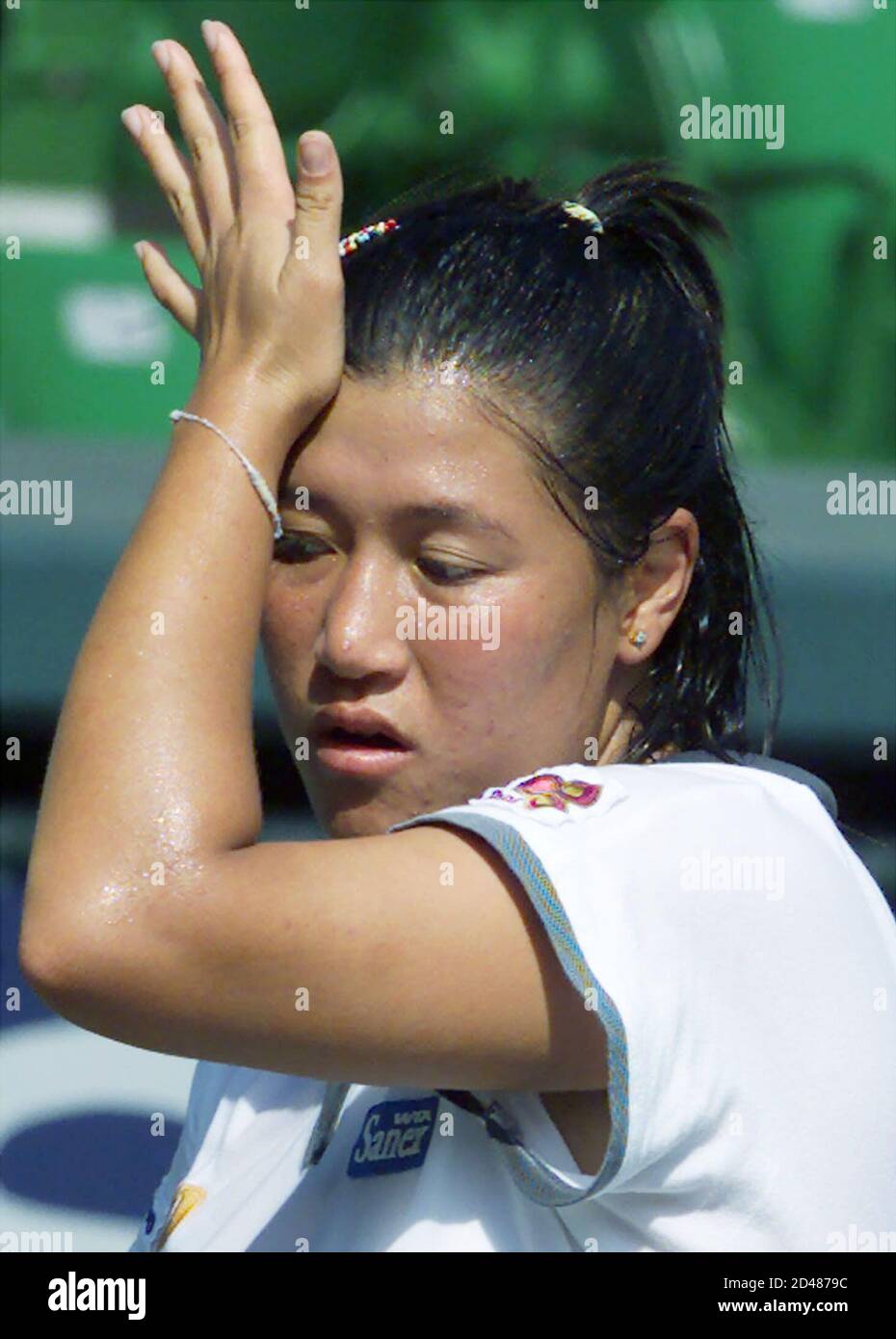 Thailand's Tamarine Tanasugarn wipes her sweat after missing a shot against  Julie Halard-Decugis of France during the women's singles semi-final match  of the Japan Open tennis tournament at Ariake Colosseum in Tokyo