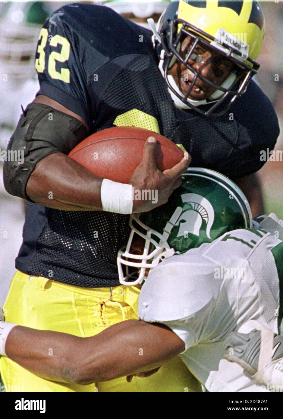 University of Michigan's Anthony Thomas (32) tries to fight off Michigan  State University's Thomas Wright October 21, 2000 after a 21-yard gain,  which set up the first of two touchdowns Thomas would