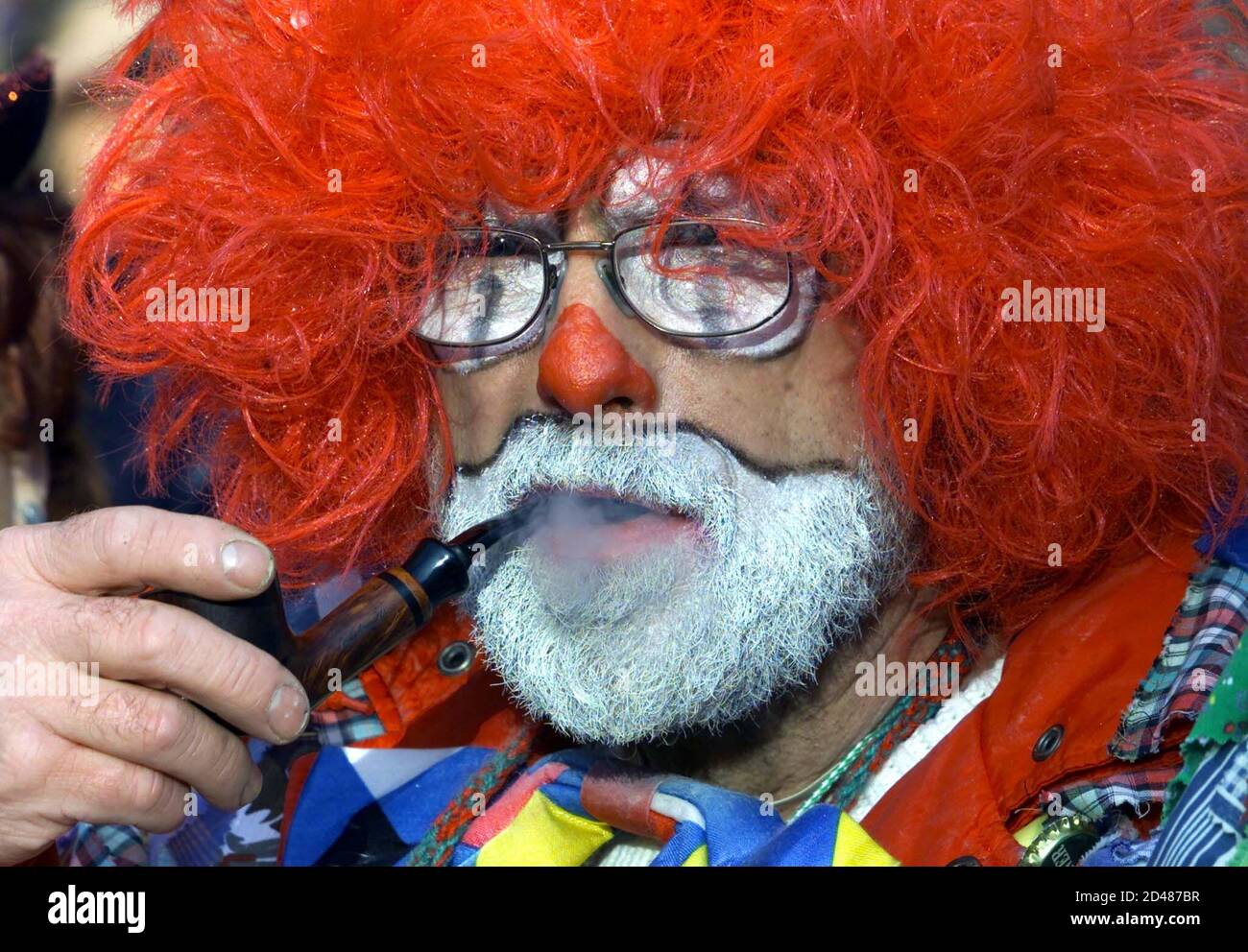 An inhabitant of the western German town of Cologne smokes a pipe dressed as a clown to celebrates the start of the carnival season in Cologne November 11, 2000. The highlight of this season will be the Rose Monday Parade in February 2001.  JS/CRB Stock Photo