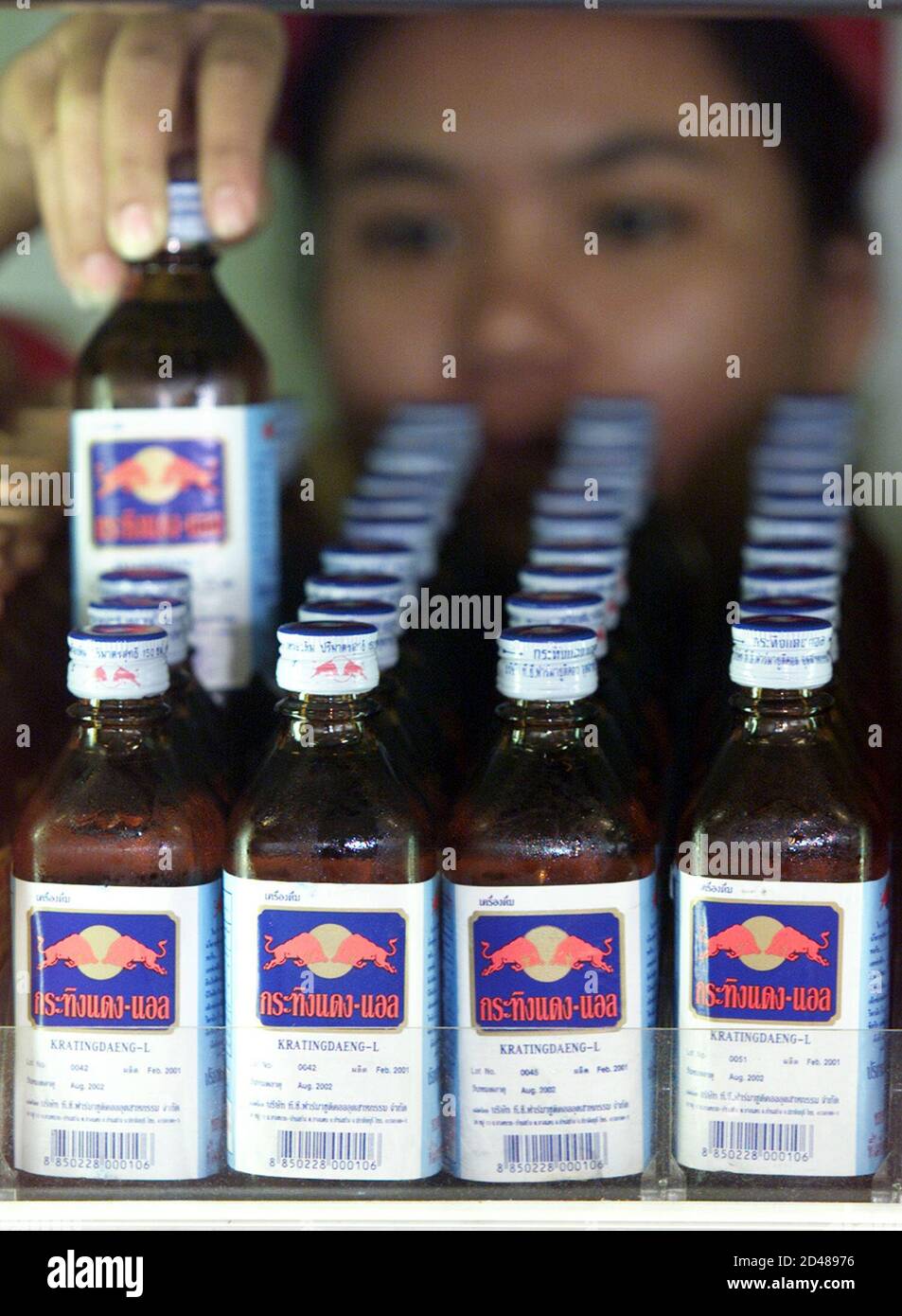 A Thai shopkeeper stocks bottles of Krating Daeng, an original Thai version  of the popular drink Red Bull, in a store in Bangkok on July 24, 2001. The  caffeinated refreshment, marketed as