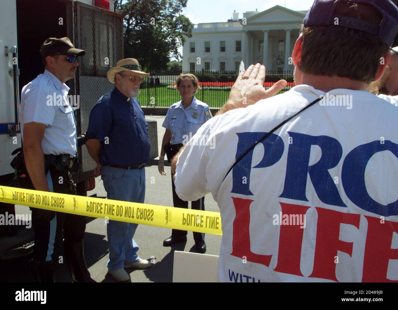 An anti-abortion protester (2L) waits to be loaded into a paddy wagon after demonstrating against stem cell research in front of the White House in Washington, September 8, 2001. About 20 protesters were arrested. REUTERS/William Philpott  WP/ME Stock Photo