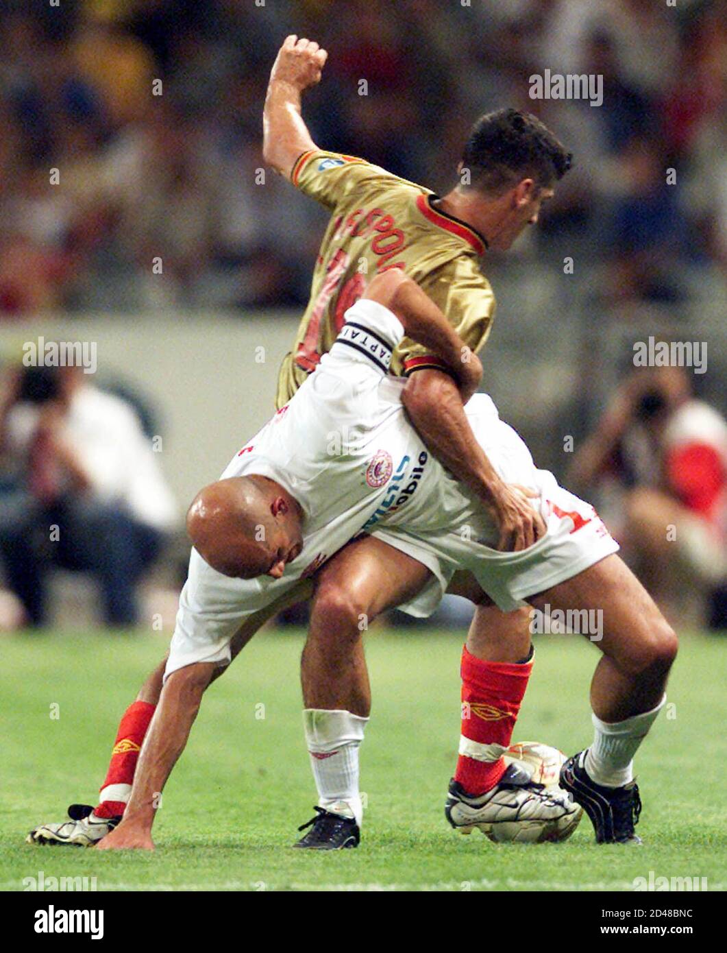 Galatasaray's Cihan Haspolatli (R) and Olympiakos' Predrag Djordjevic (L)  wrestle for the ball during a game between Turkey's Galatasaray and Greek  Olympiakos in the Olympic Stadium in Istanbul July 31, 2002. Istanbul's