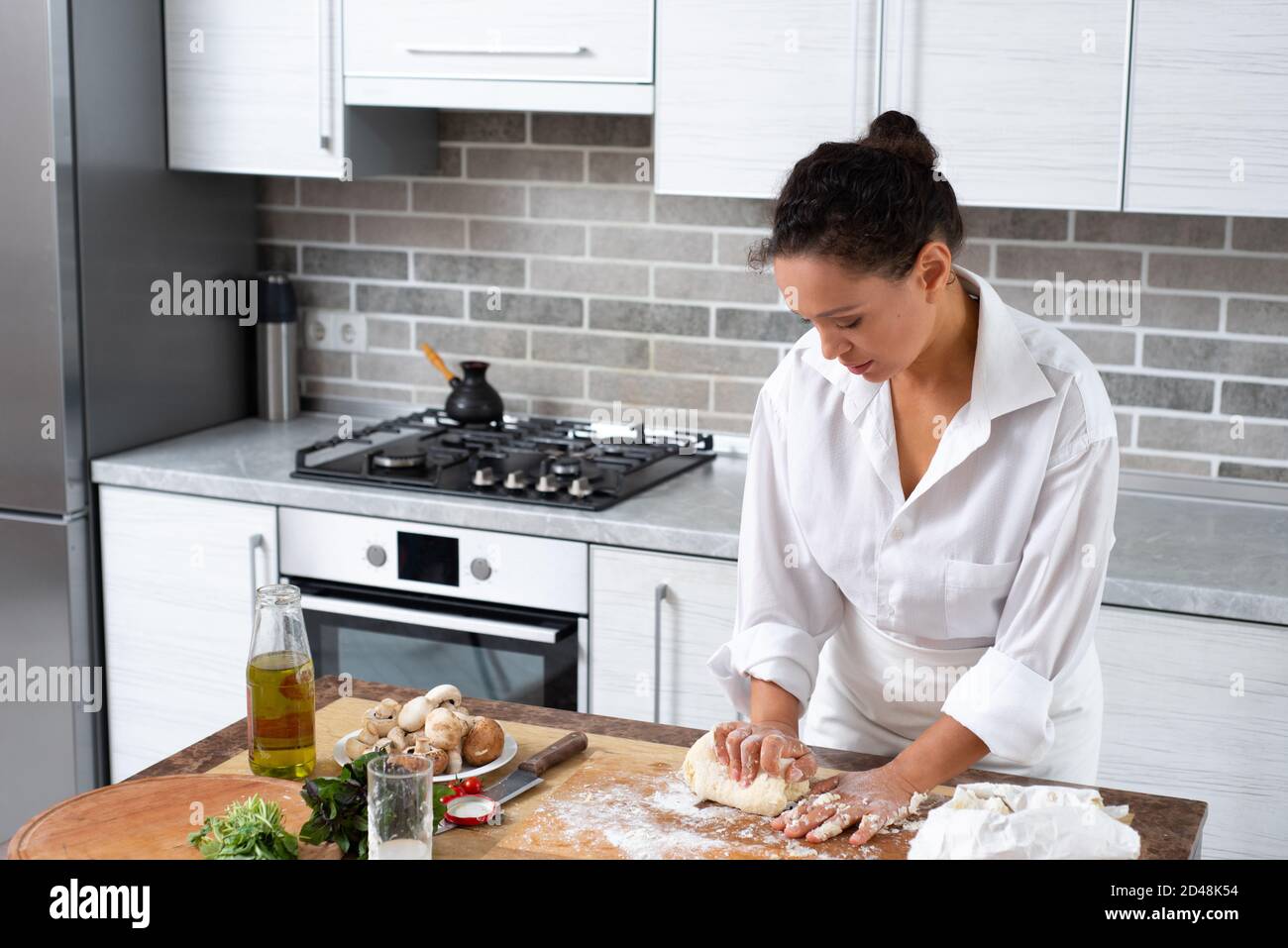 Portrait of the woman chef kneading dough in her kitchen Stock Photo ...