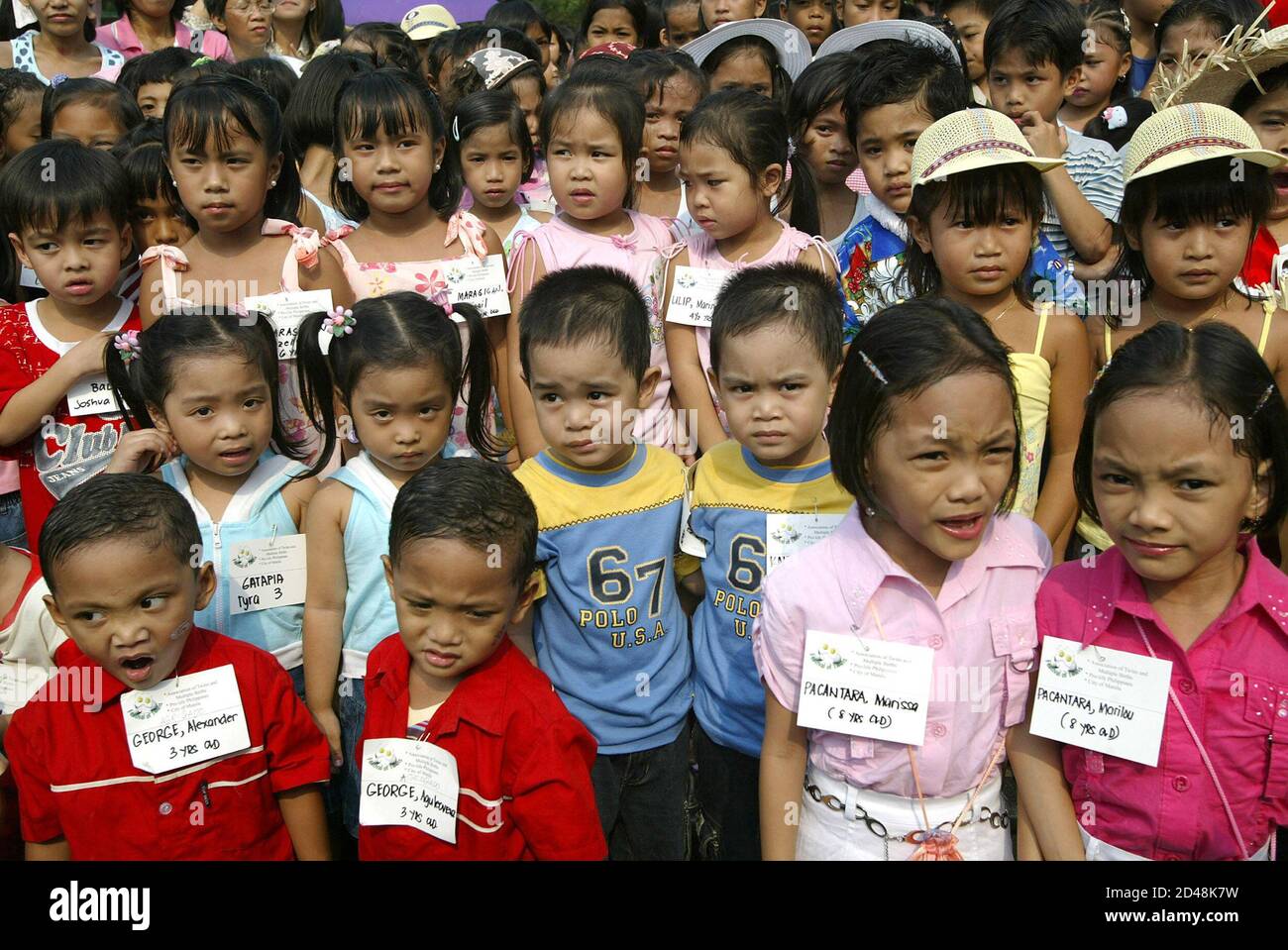 Filipino twin children stand in rows during the 2nd annual Festival of Twins  and Multiple Births in Manila. Filipino twin children stand in rows during  the 2nd annual Festival of Twins and