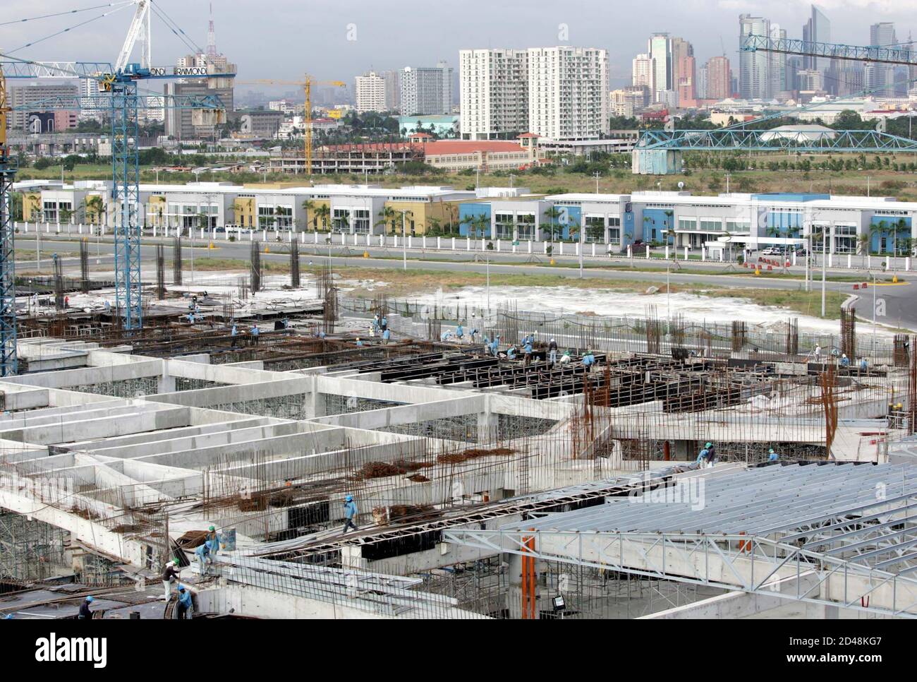 Manila's skyline is seen at the construction site of the Philippines' largest shopping centre, Mall of Asia.  Manila's skyline is seen at the construction site of the Philippines' largest shopping centre, Mall of Asia, owned by SM Investments Corp (SMIC), near Manila Bay March 21, 2005. Shares in SMIC are expected to rise five to 10 percent when they debut on Tuesday following the Philippines' largest IPO, driven by strong foreign demand and confidence in its prospects. REUTERS/Erik de Castro Stock Photo