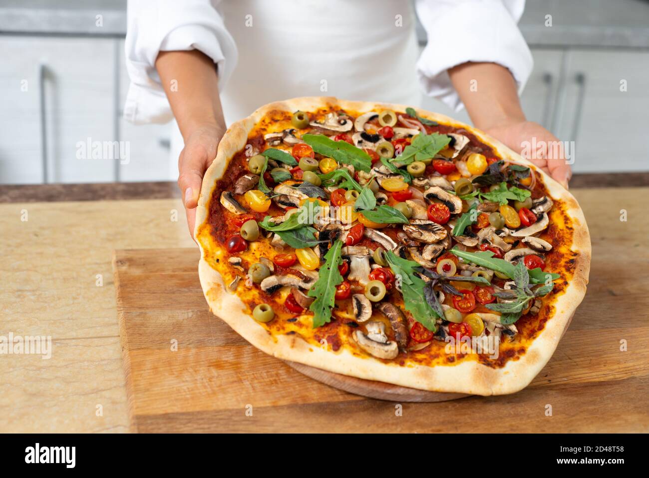 Сhef demonstrates a readytoeat pizza without cheese. Vegan food