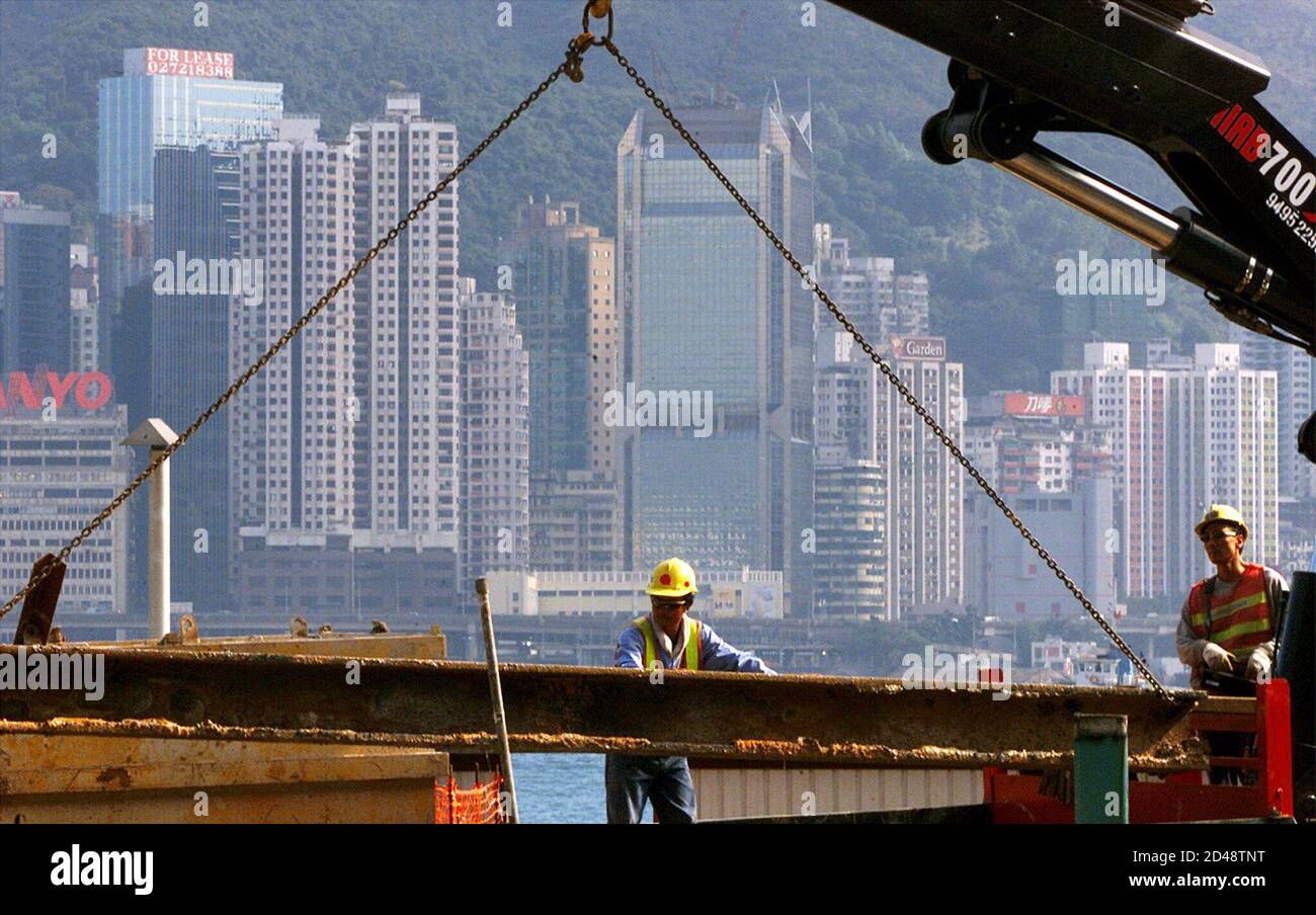 Workers unload a steel bar at a construction site in Hong Kong December 19, 2001. [The construction industry has been hard hit as the territory's jobless rate reached 5.8 percent in the September-November period, its highest level in nearly two years.] Stock Photo