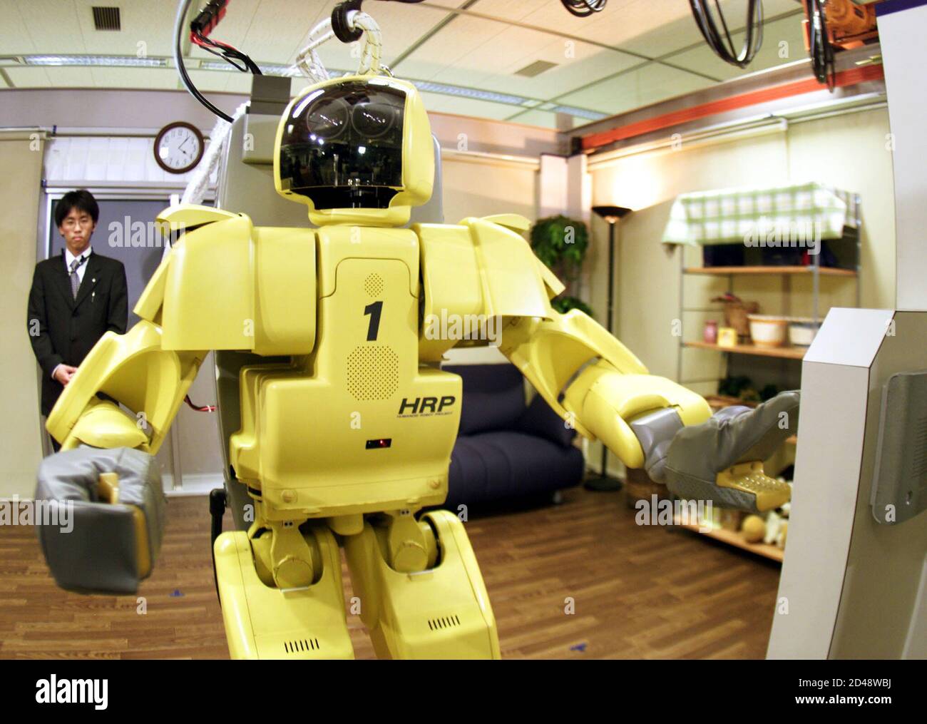 A humanoid robot checks an intercom during a demonstration in Tsukuba,  north of Tokyo April 10, 2002. Japan, the robot leader of the world, has  been conducting a five-year reseach and development