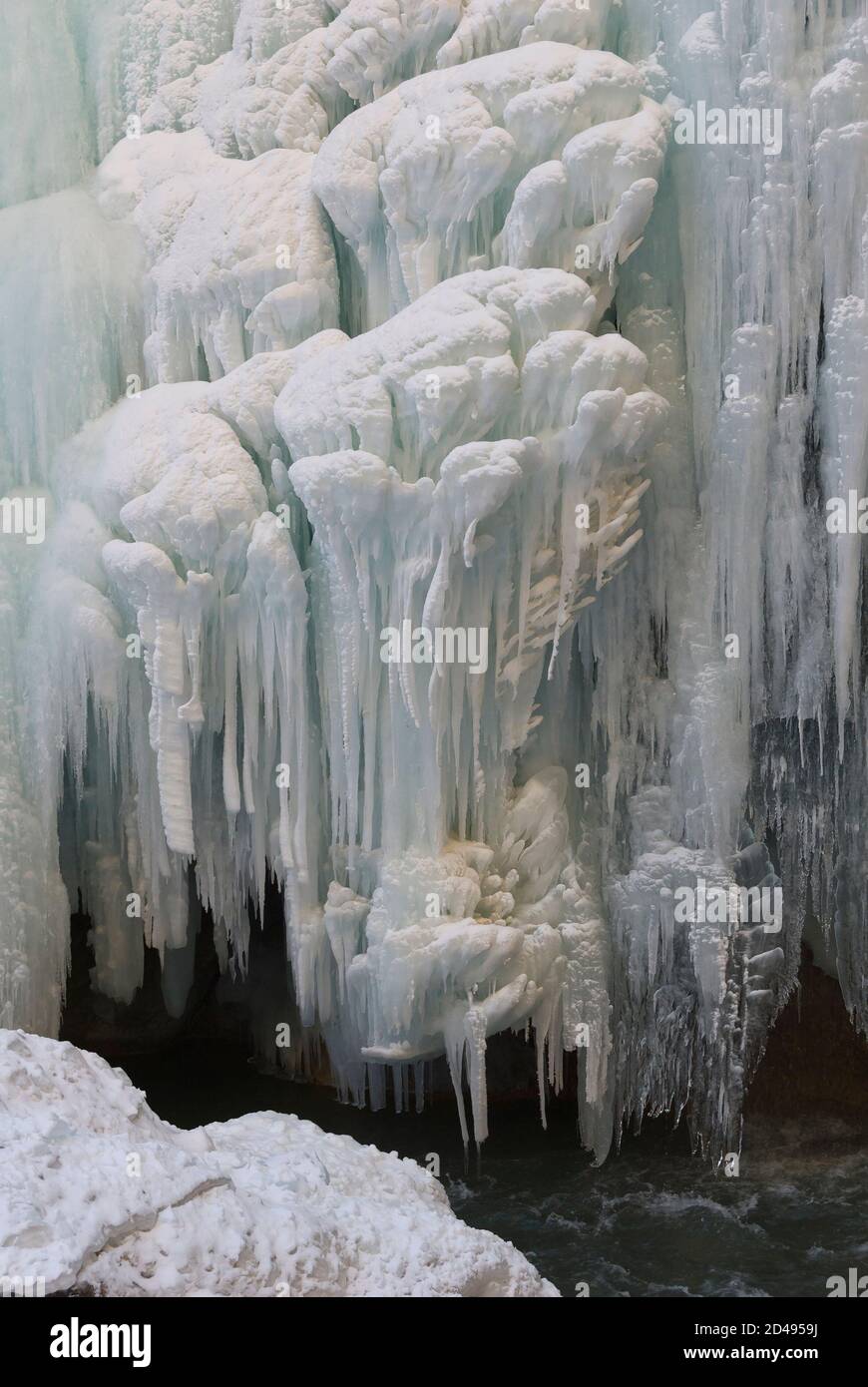 Frozen waterfall with huge beautiful icicles hanging from the rocks ...
