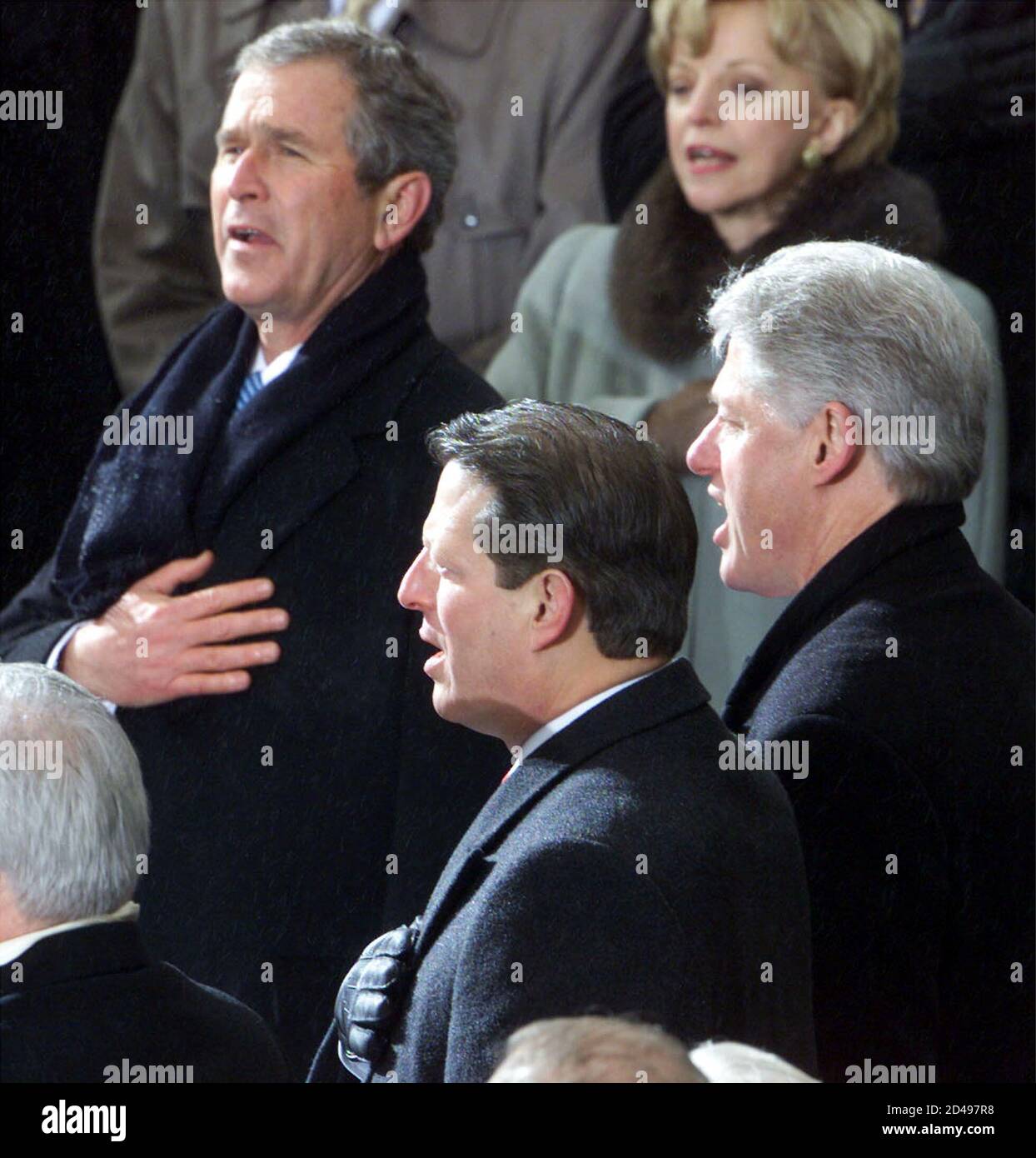 George W. Bush sings the national anthem standing with former president Bill Clinton (R) and vice president Al Gore, in Washington, January 20, 2001. Bush was sworn in as the 43rd President of the United States. Stock Photo