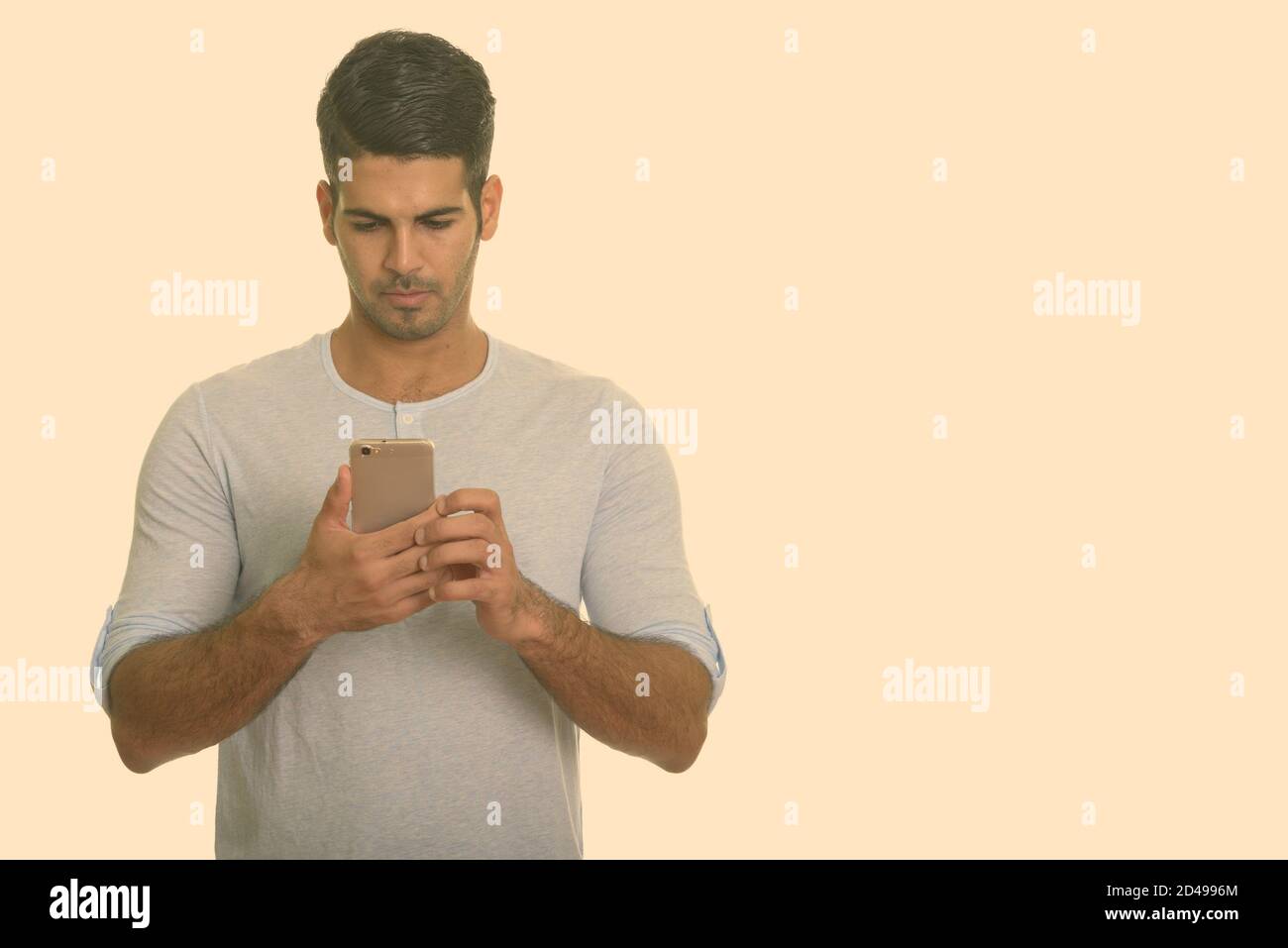 Young handsome Persian man using mobile phone Stock Photo